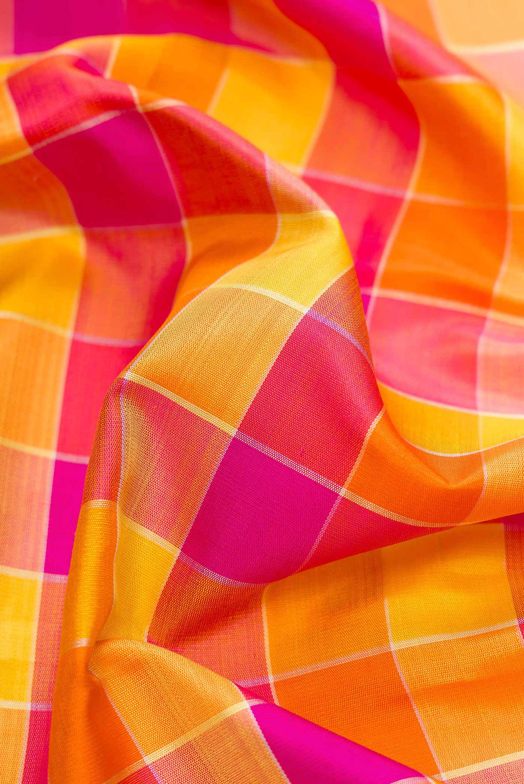 Close up of Orange, Pink and Mustard Color Kanjivaram Silk Saree with Checked design on the body and Zari Border.  displaying folds