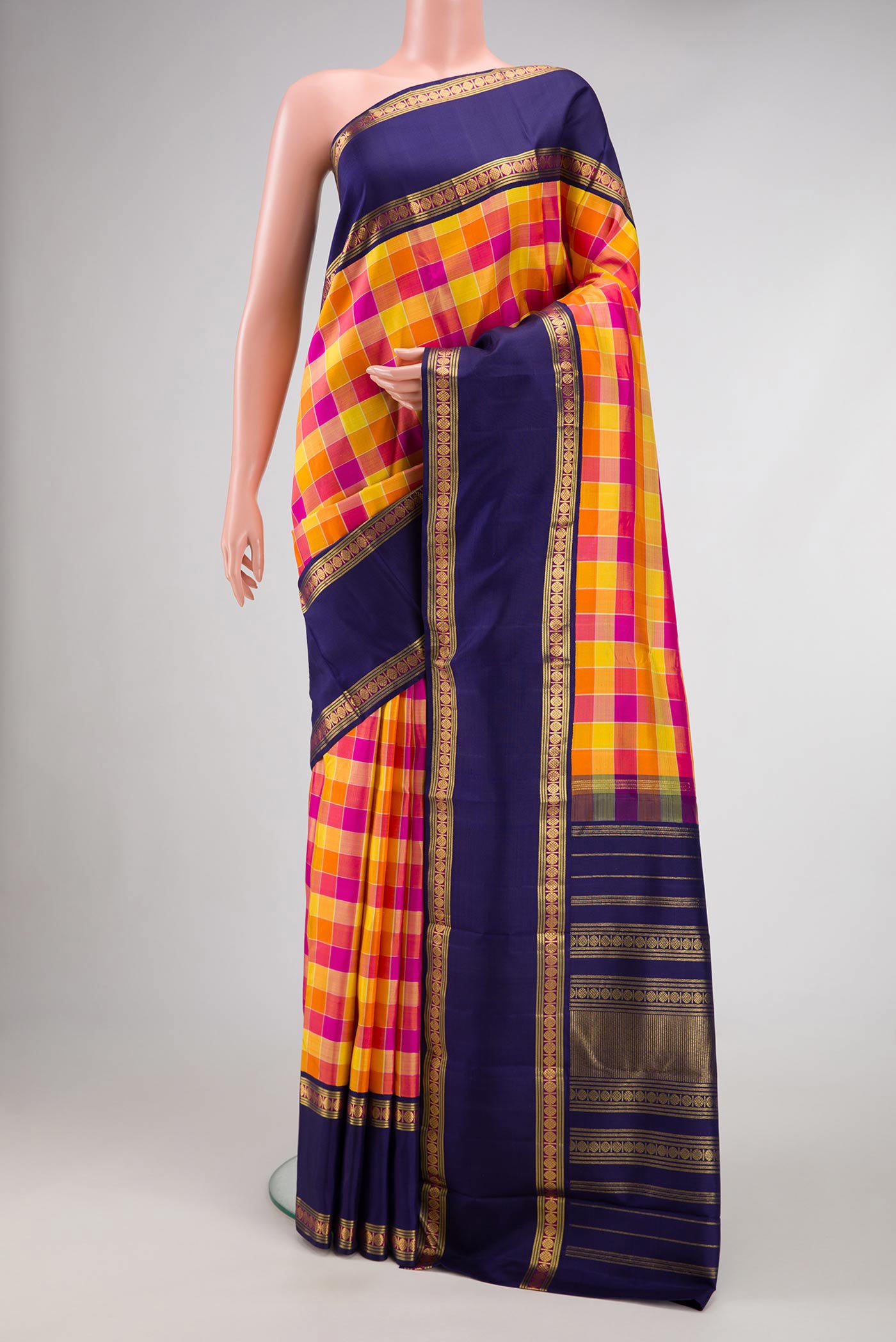 Orange, Pink and Mustard Color Kanjivaram Silk Saree with Checked design on the body and Zari Border.  displayed on a mannequin