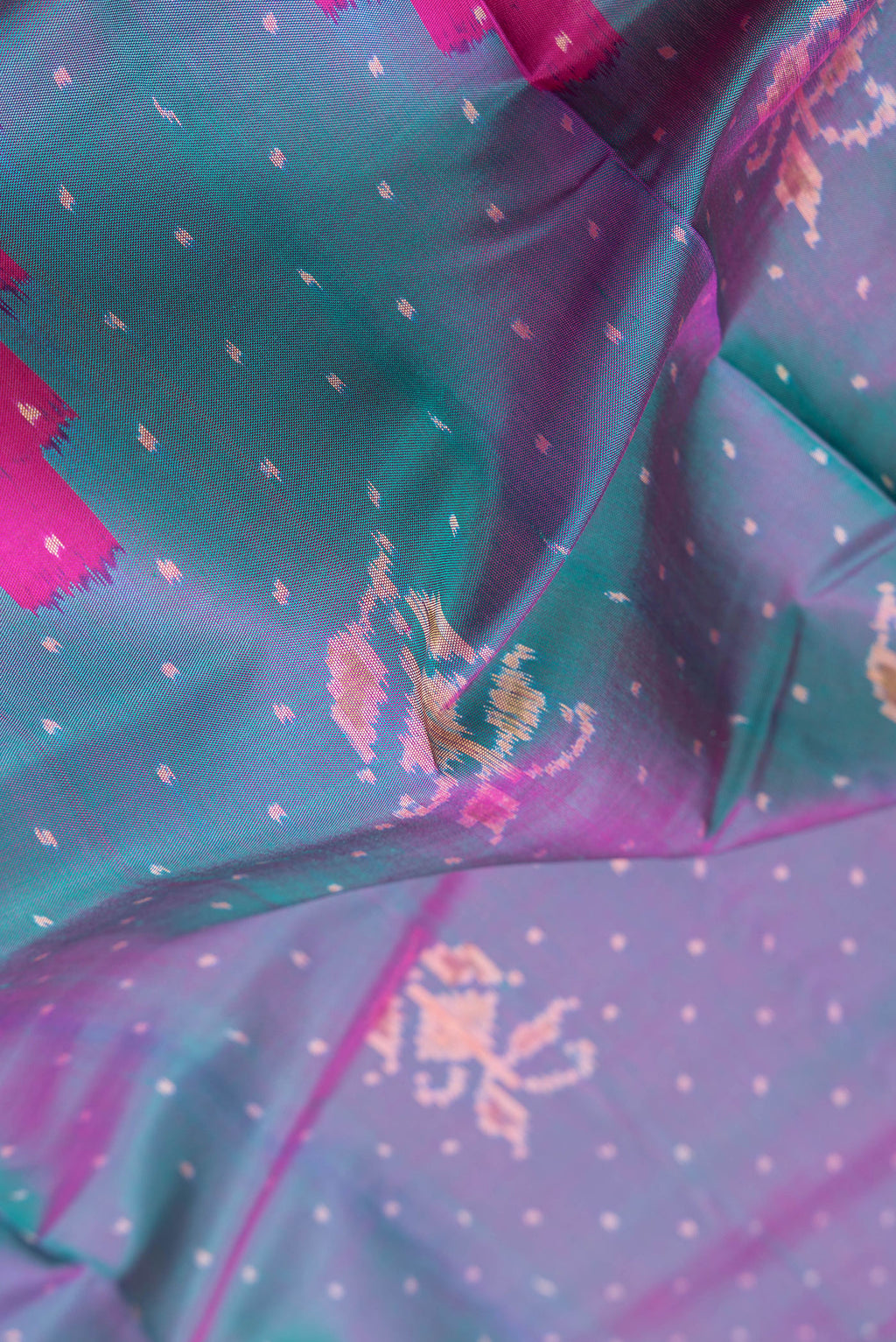 Close up of Peacock Blue Dual Tone Double Ikat Saree with Ikat Print on the body and Ikat Border.  displaying folds
