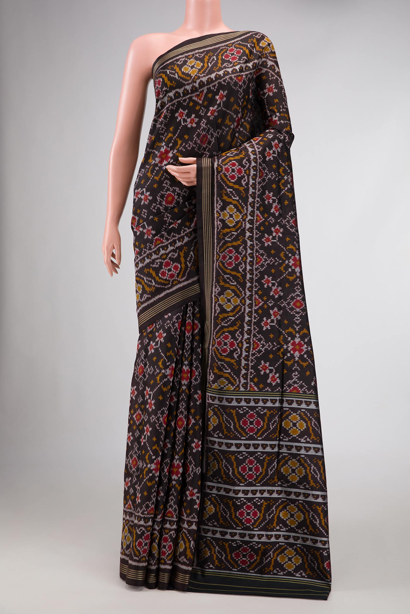 Black Dual Tone Rajkot Patola Silk Saree with Ikat Print on the body and Zari Border.  displayed on a mannequin