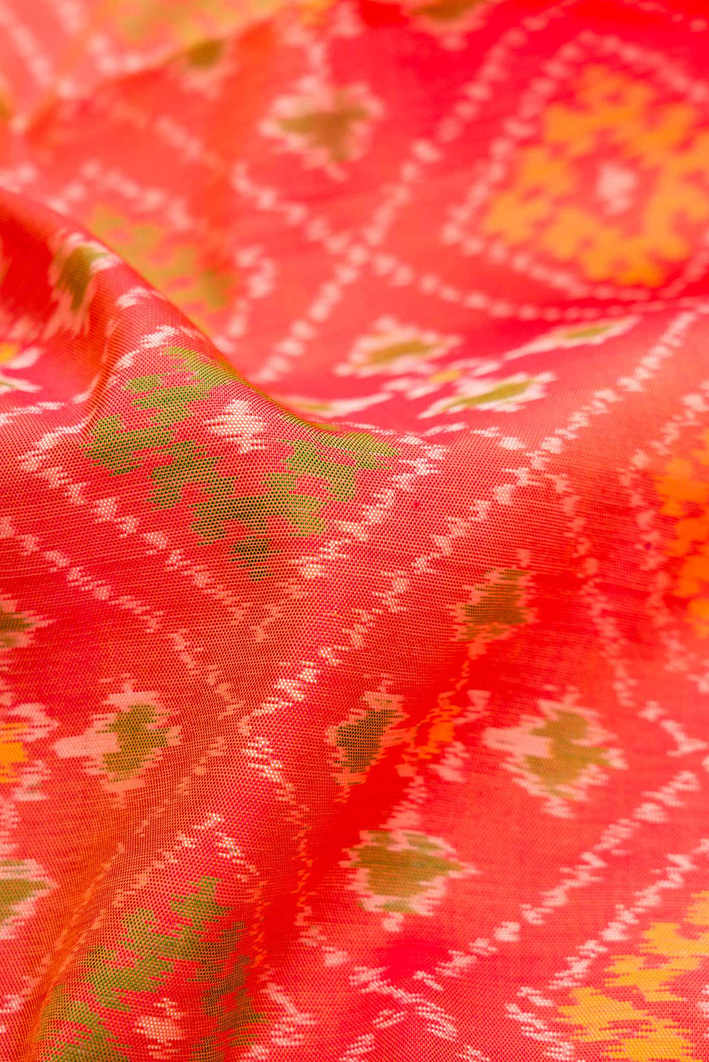 Close up of Orange Dual Tone Rajkot Patola Silk Saree with Ikat Print on the body and Zari Border.  displaying folds