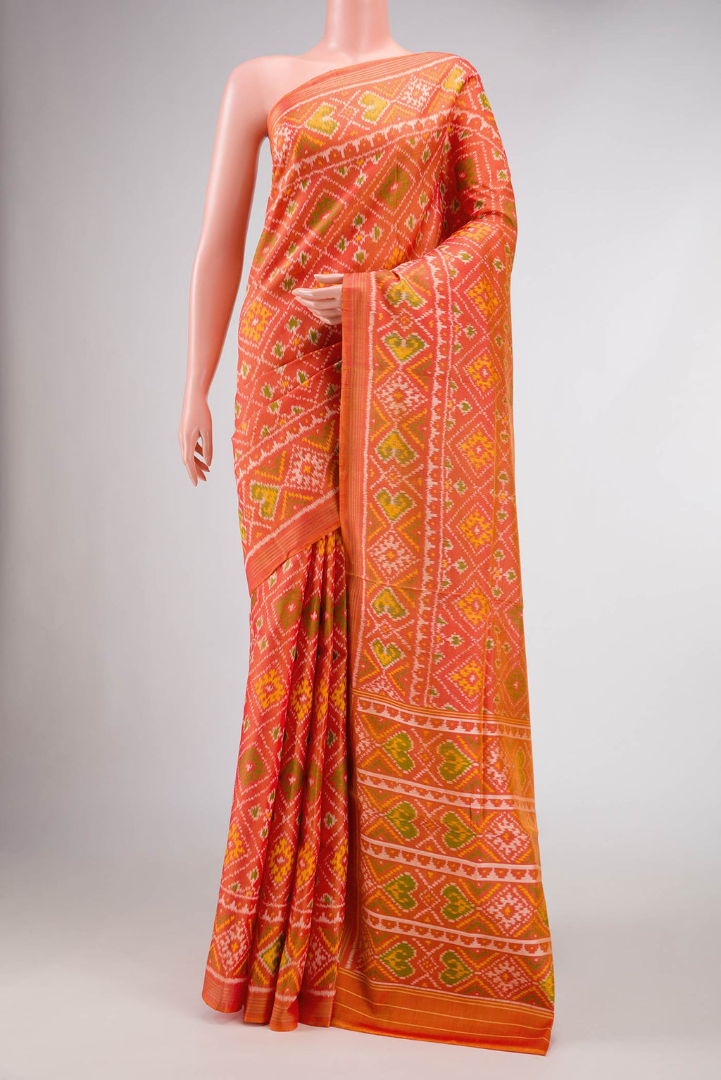 Orange Dual Tone Rajkot Patola Silk Saree with Ikat Print on the body and Zari Border.  displayed on a mannequin