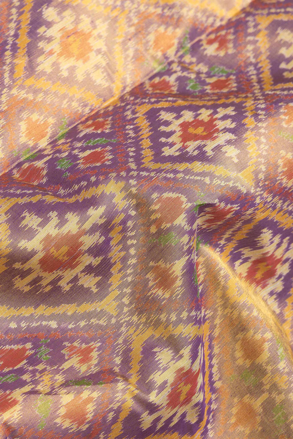 Close up of Lavender Dual Tone Double Ikat Saree with Ikat Print on the body and Zari Border.  displaying folds
