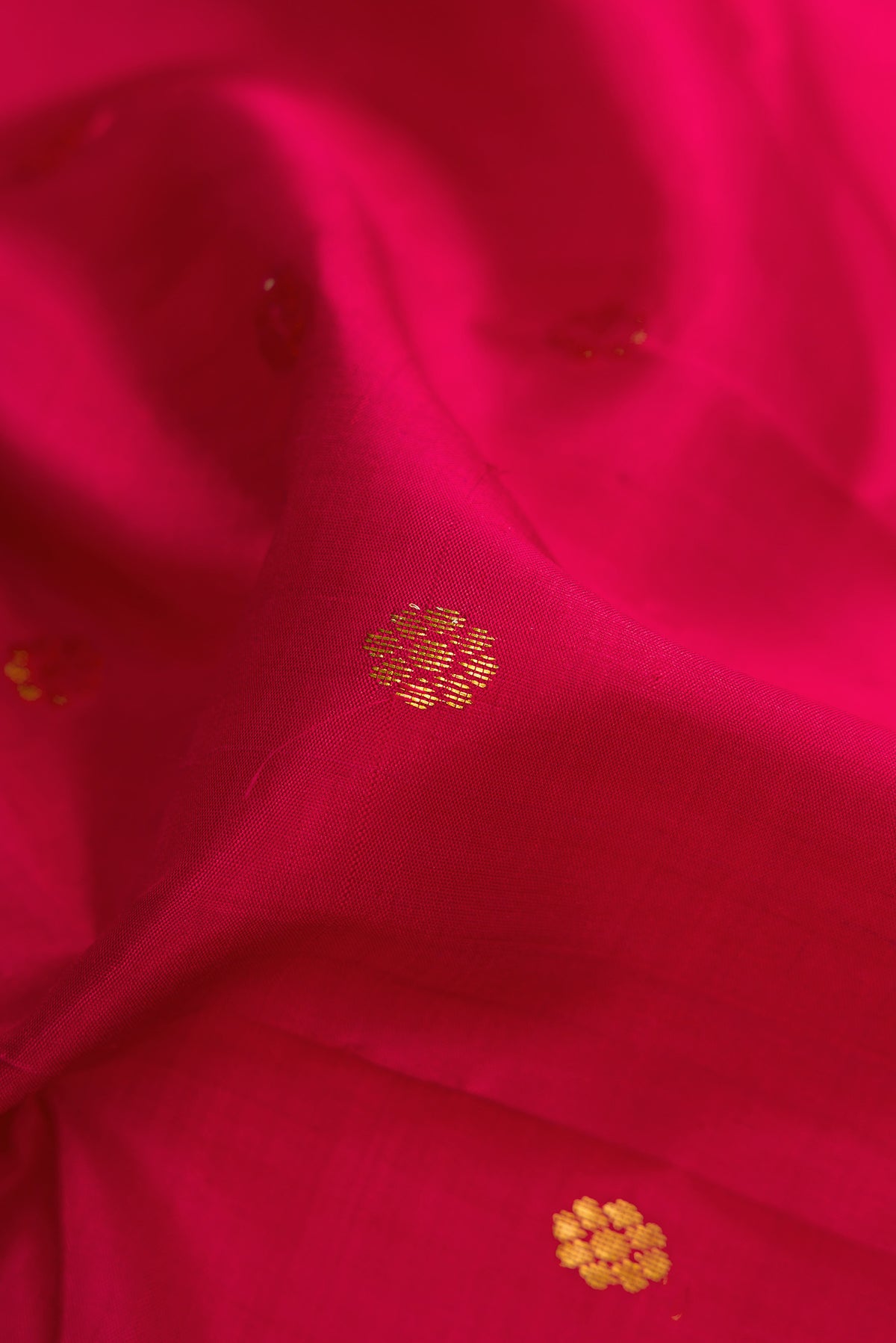 Close up of Maroon Dual Tone Kanchipuram Silk Saree with Zari Butta on the body and Zari Border.  displaying folds