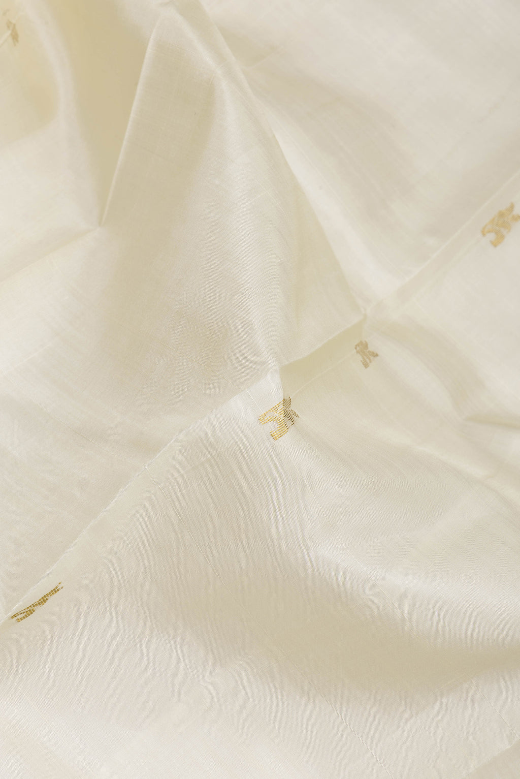 Close up of Off White Kanjivaram Silk Saree with Zari Butta on the body and One Side Border.  displaying folds