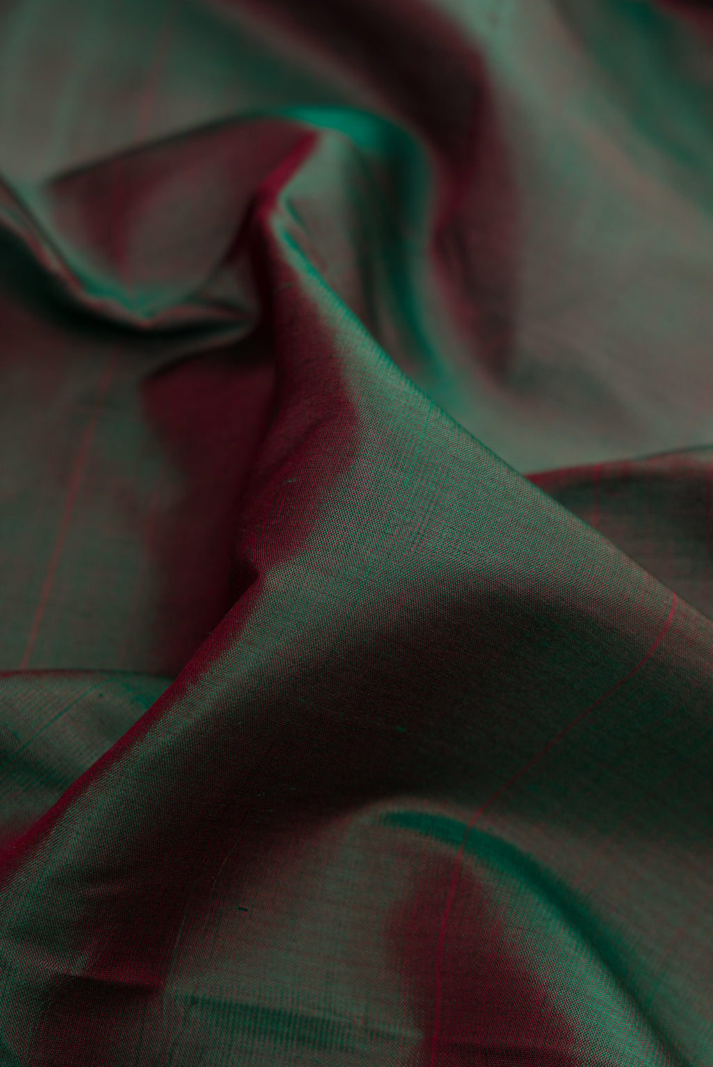Close up of Bottle Green Dual Tone Kanchipuram Silk Saree with Plain Body and Zari Border.  displaying folds