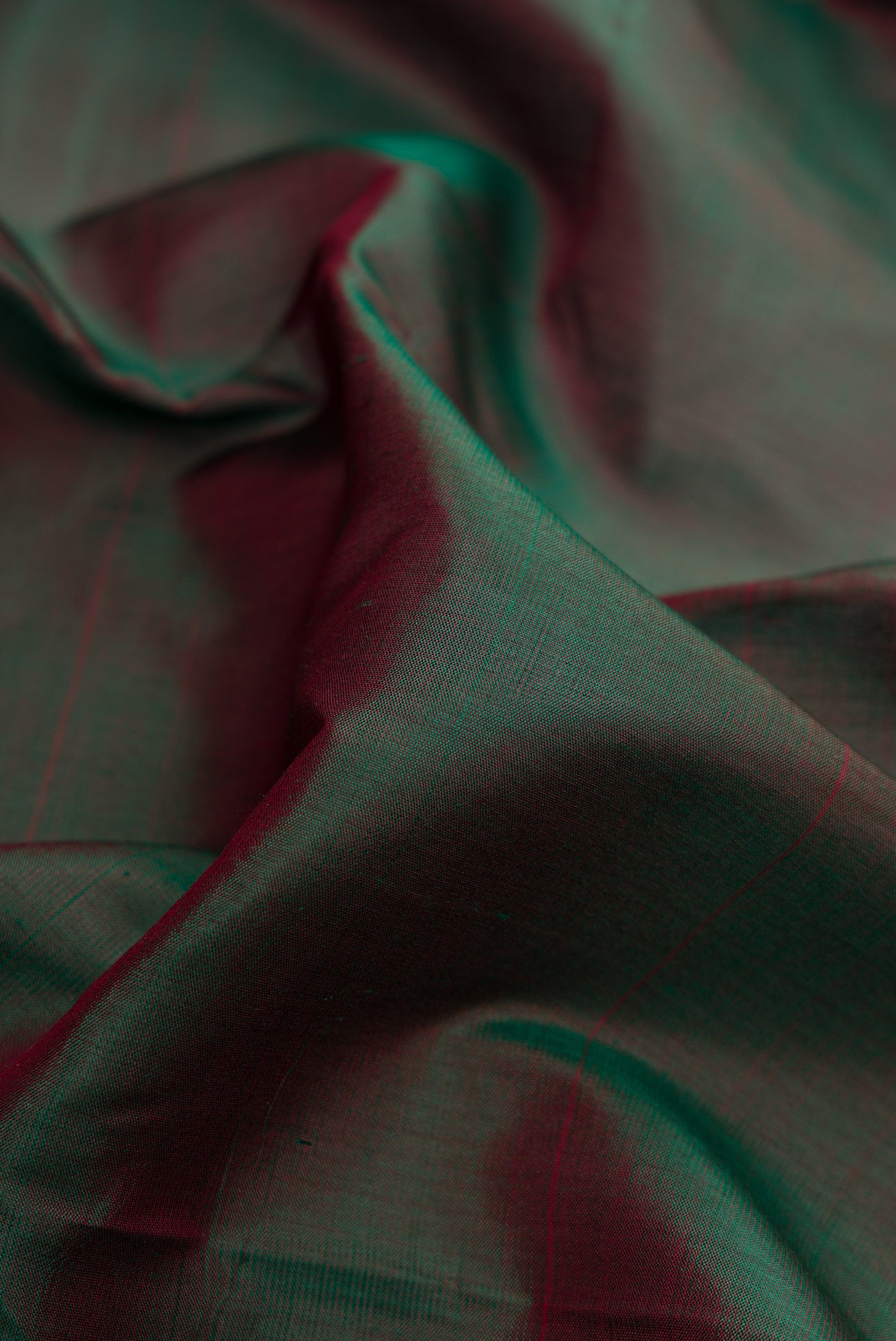 Close up of Bottle Green Dual Tone Kanchipuram Silk Saree with Plain Body and Zari Border.  displaying folds