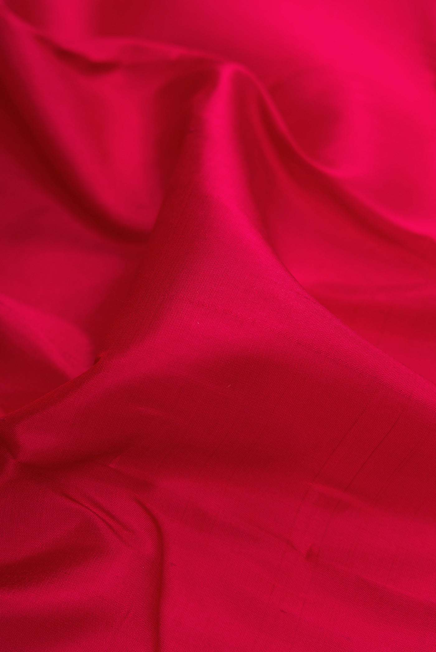 Close up of Maroon Dual Tone Kanchipuram Silk Saree with Plain Body and Zari Border.  displaying folds