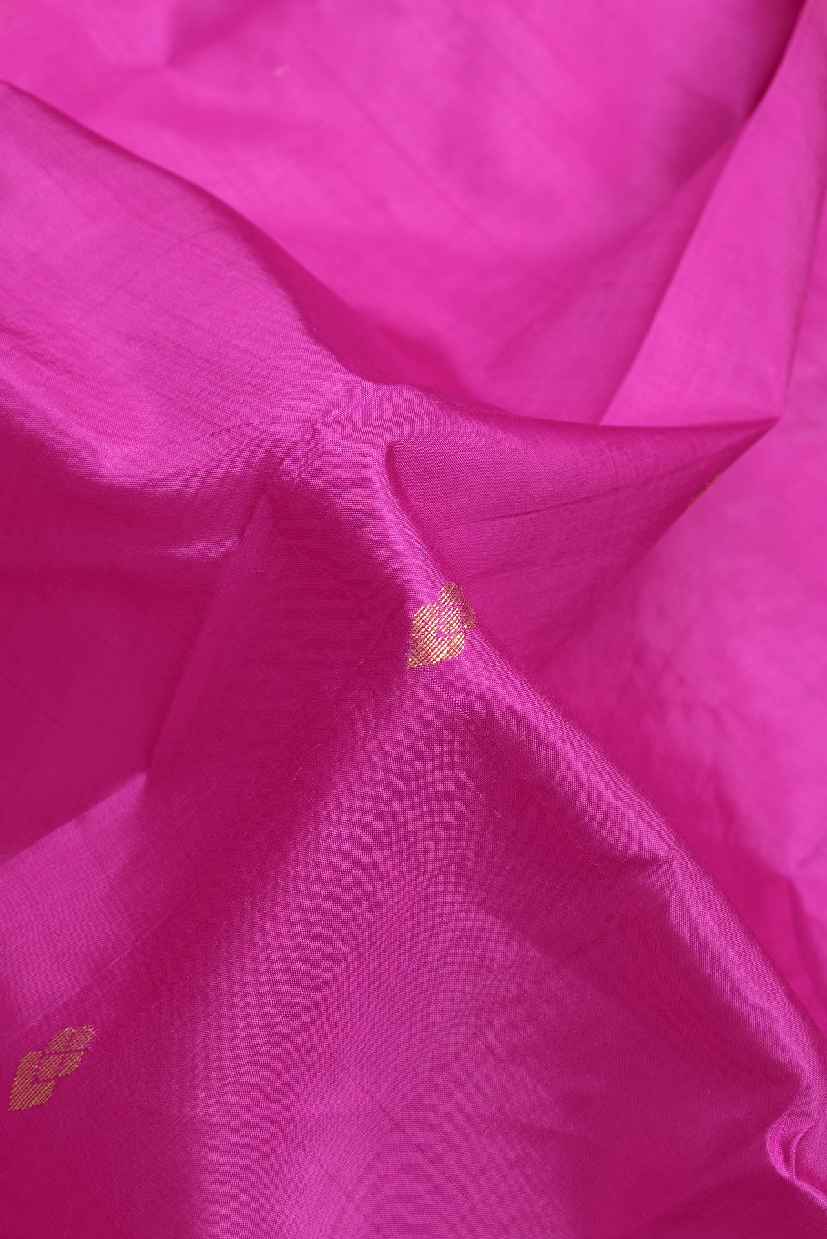 Close up of Magenta Kanjivaram Silk Saree with Zari Butta on the body and One Side Border.  displaying folds