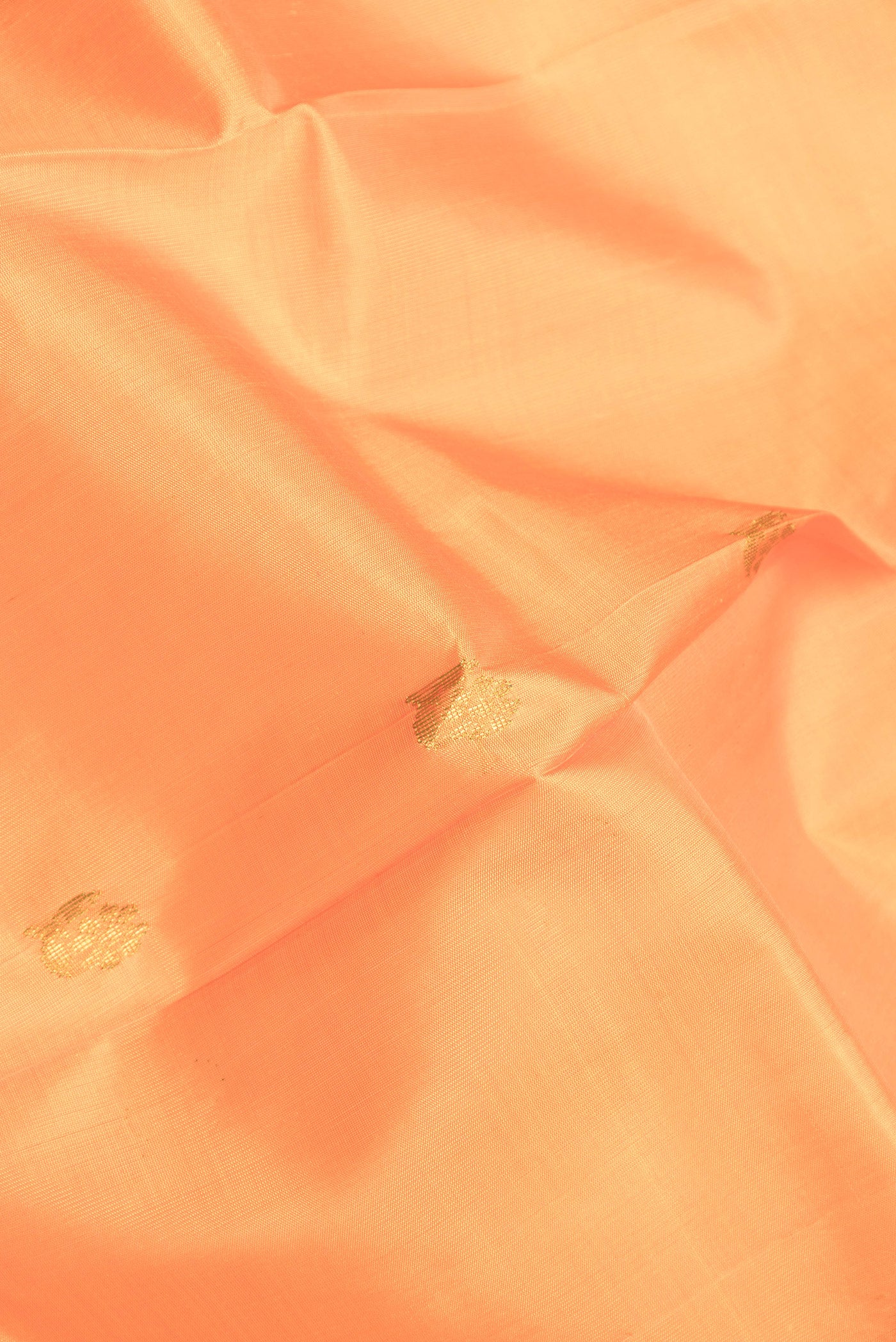 Close up of Orange Dual Tone Kanjivaram Silk Saree with Zari Butta on the body and One Side Border.  displaying folds
