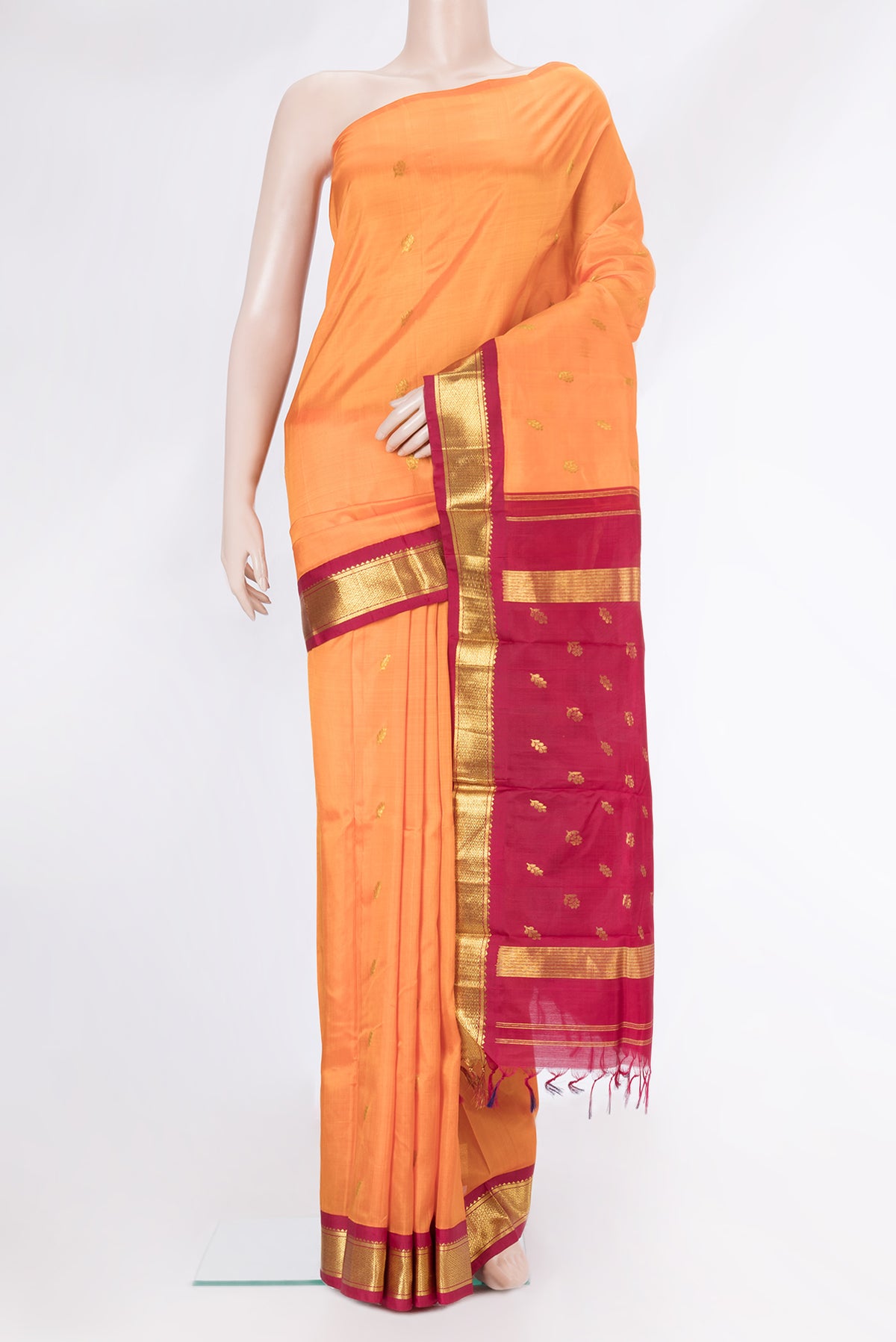 Orange Dual Tone Kanjivaram Silk Saree with Zari Butta on the body and One Side Border.  displayed on a mannequin