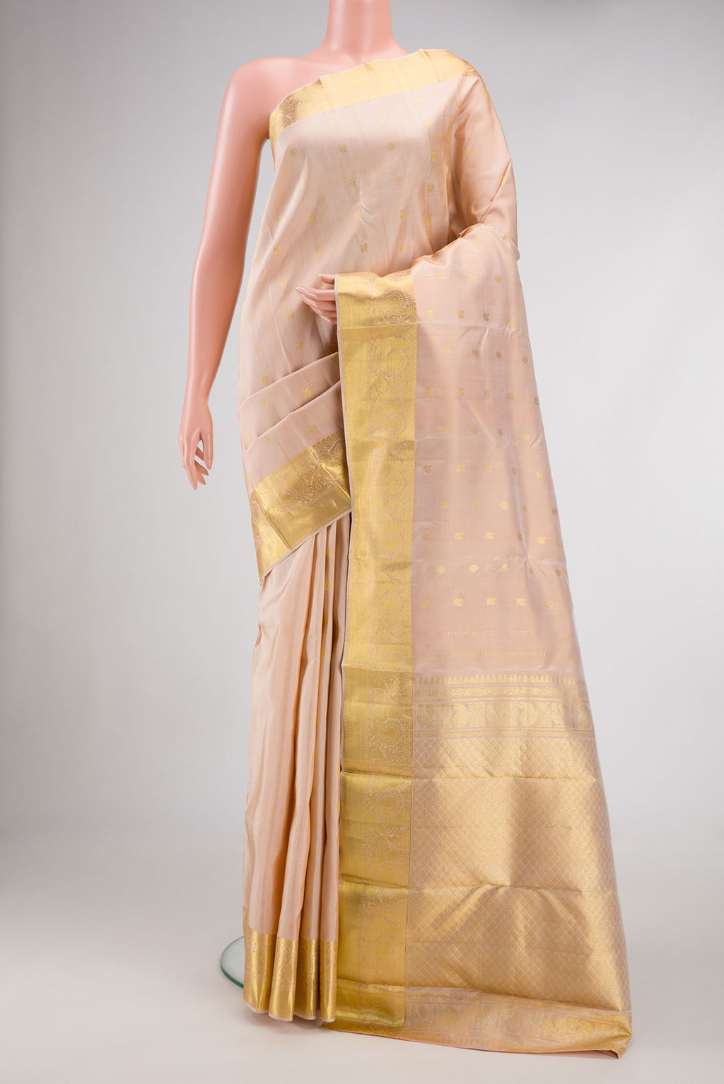 Rose Gold Dual Tone Kanjivaram Silk Saree with Zari Butta on the body and Zari Border.  displayed on a mannequin