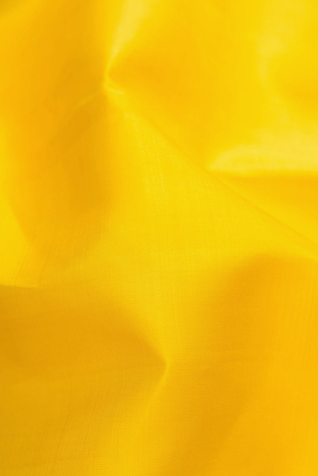 Close up of Lemon Yellow Dual Tone Kanjivaram Silk Saree with Plain Body and Zari Border.  displaying folds