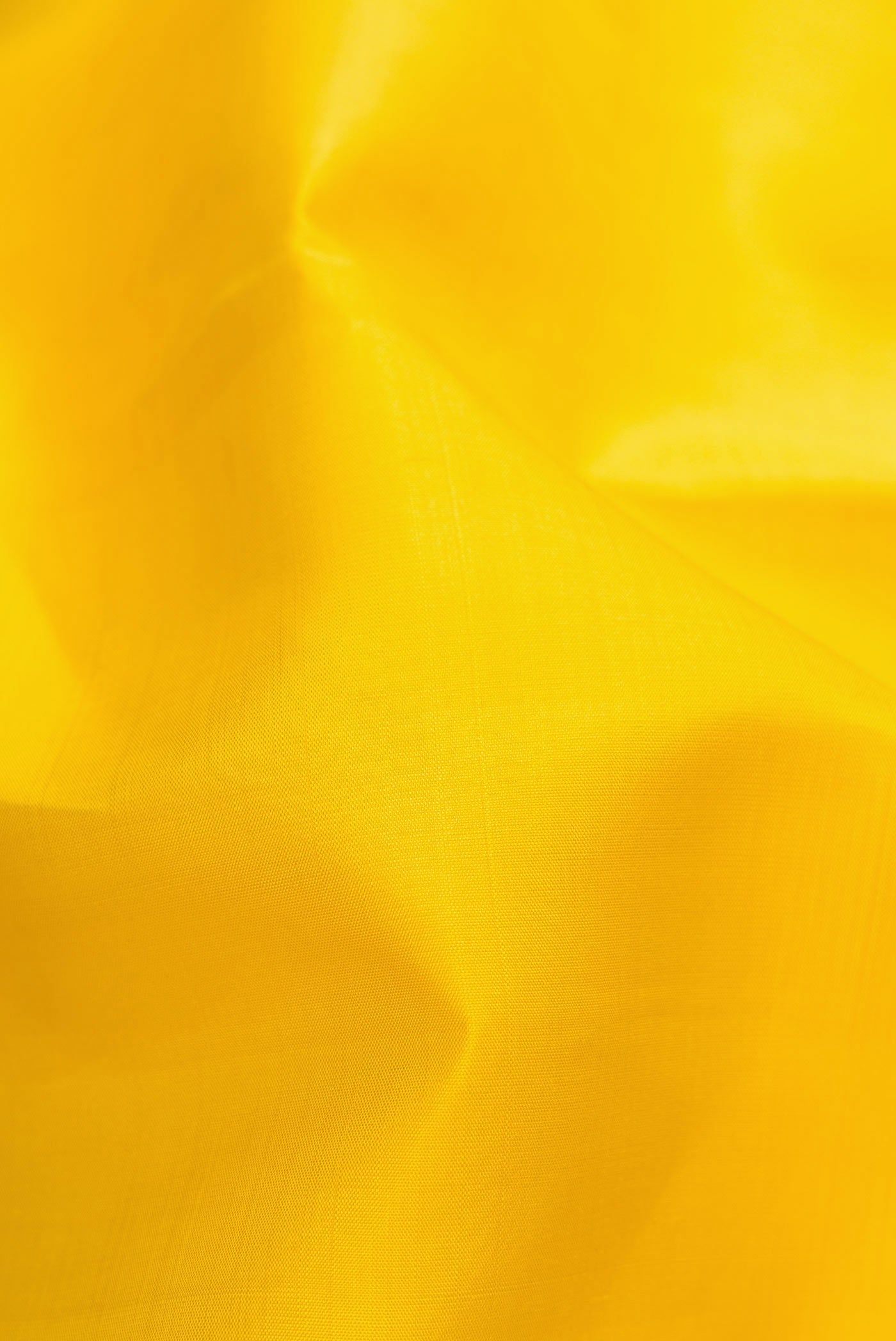 Close up of Lemon Yellow Dual Tone Kanjivaram Silk Saree with Plain Body and Zari Border.  displaying folds