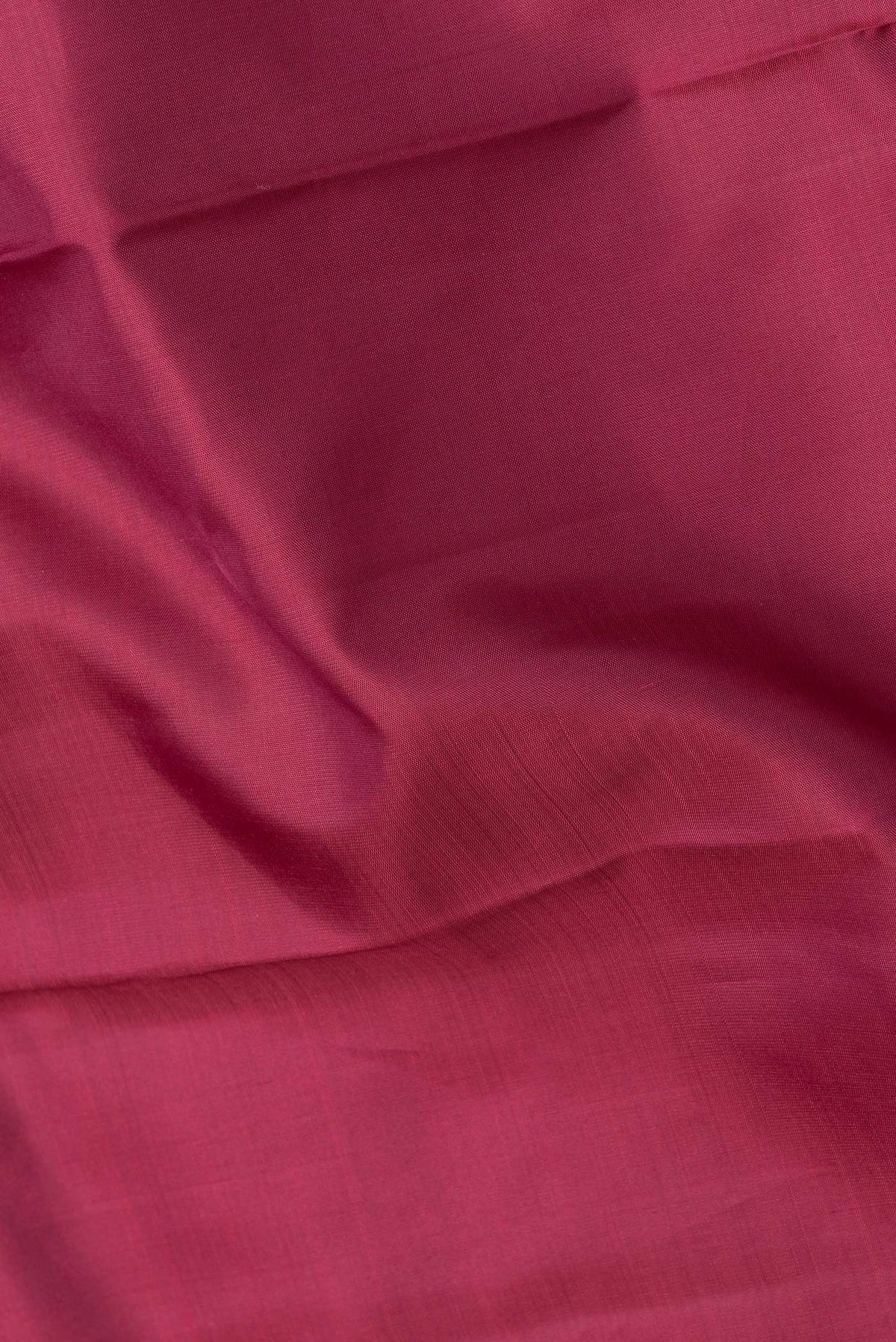 Close up of Maroon Dual Tone Kanjivaram Silk Saree with Plain Body and Zari Border.  displaying folds