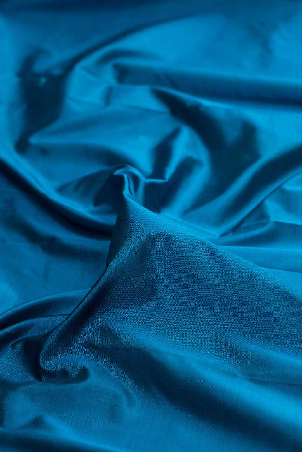 Close up of Pure Silk Peacock Blue Bangalore Saree with Plain Body and Temple Border.  displaying folds