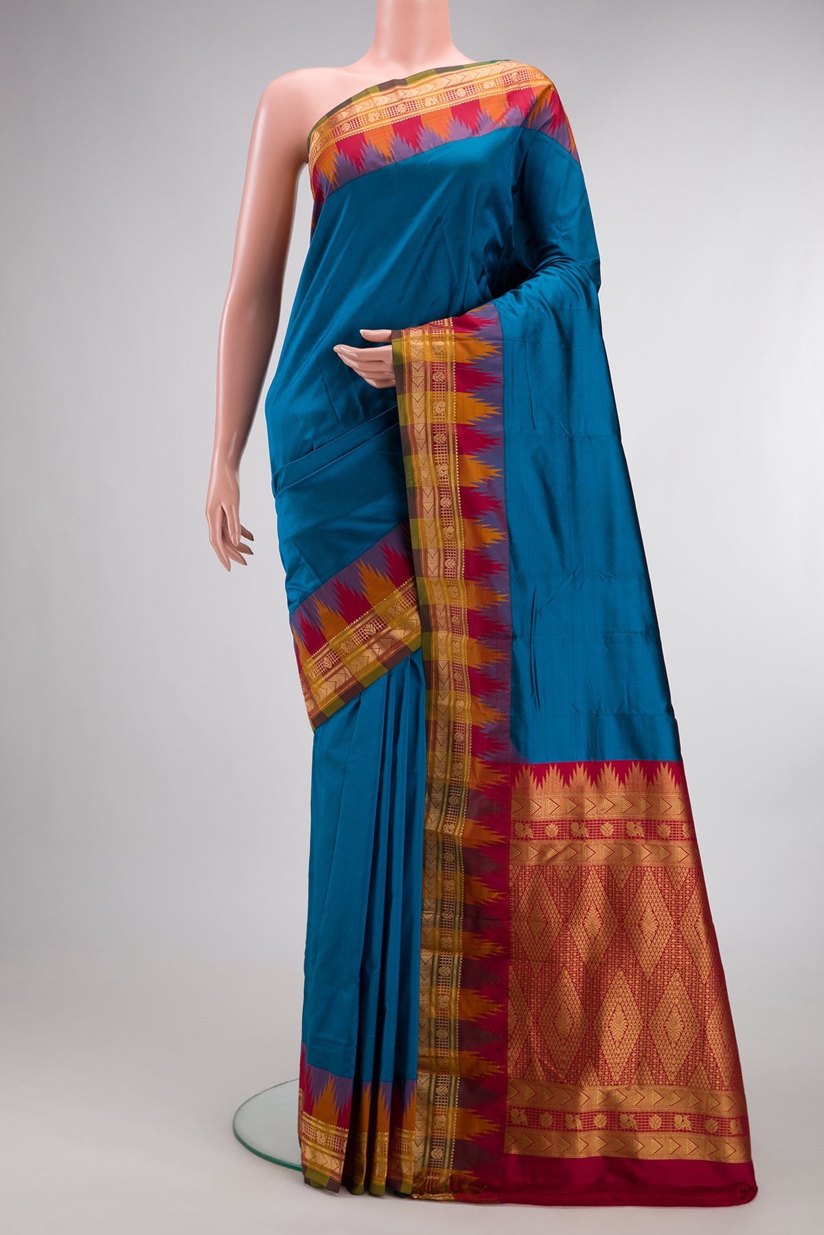 Pure Silk Peacock Blue Bangalore Saree with Plain Body and Temple Border.  displayed on a mannequin