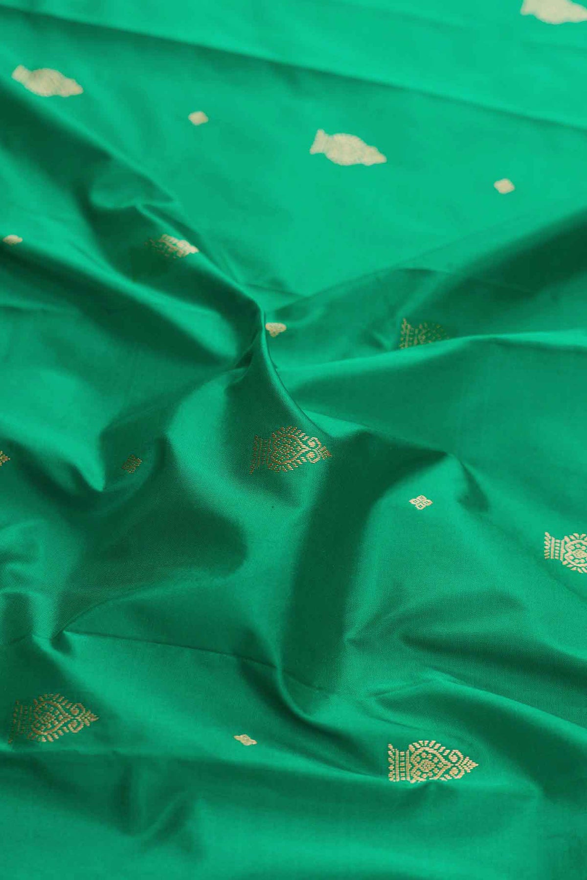 Close up of Green Bangalore Silk Saree with Zari Butta on the body and Temple Border displaying folds