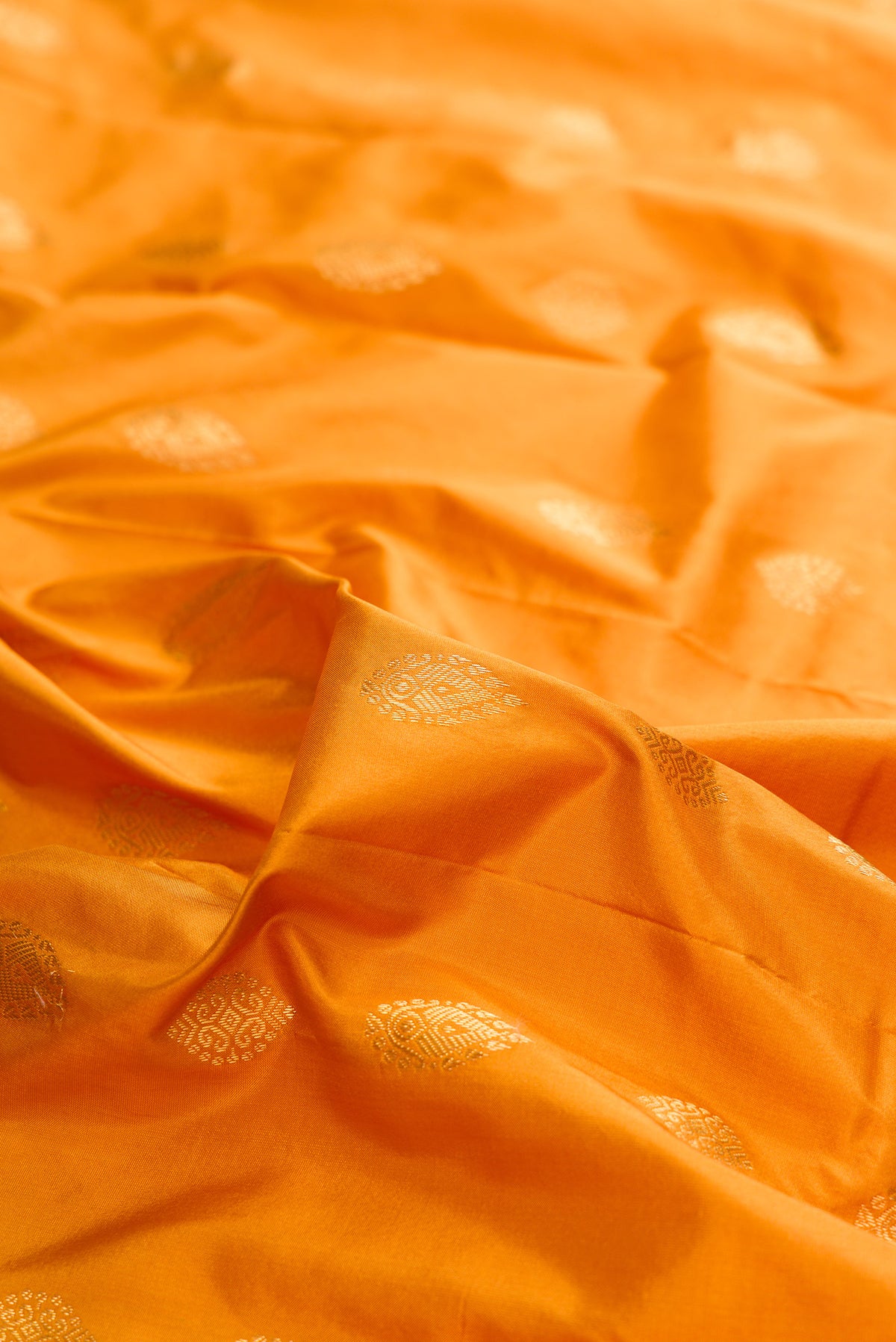 Close up of Pure Silk Mustard Bangalore Saree with Zari Butta on the body and Temple Border.  displaying folds