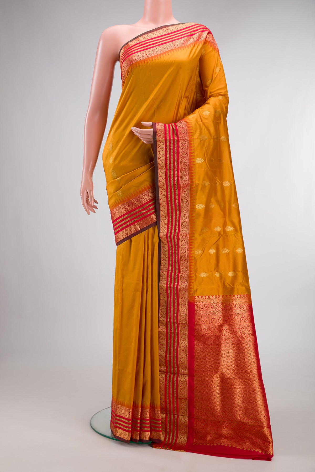 Pure Silk Mustard Bangalore Saree with Zari Butta on the body and Temple Border.  displayed on a mannequin
