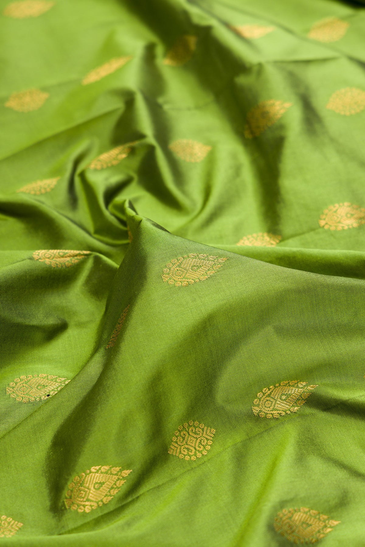Close up of Pure Silk Mehandi Green Bangalore Saree with Zari Butta on the body and Temple Border.  displaying folds