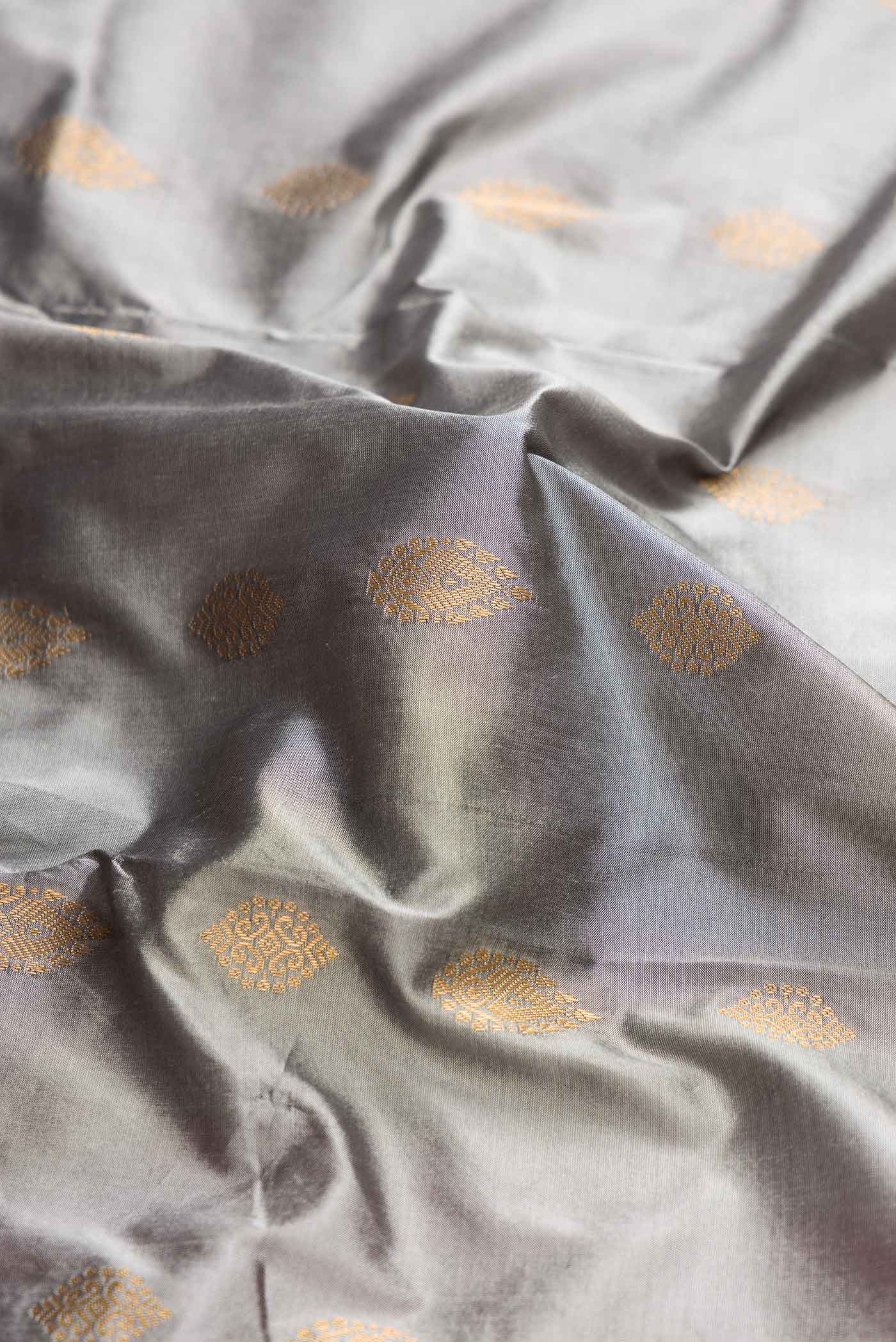 Close up of Grey Bangalore Silk Saree with Zari Butta on the body and Temple Border displaying folds