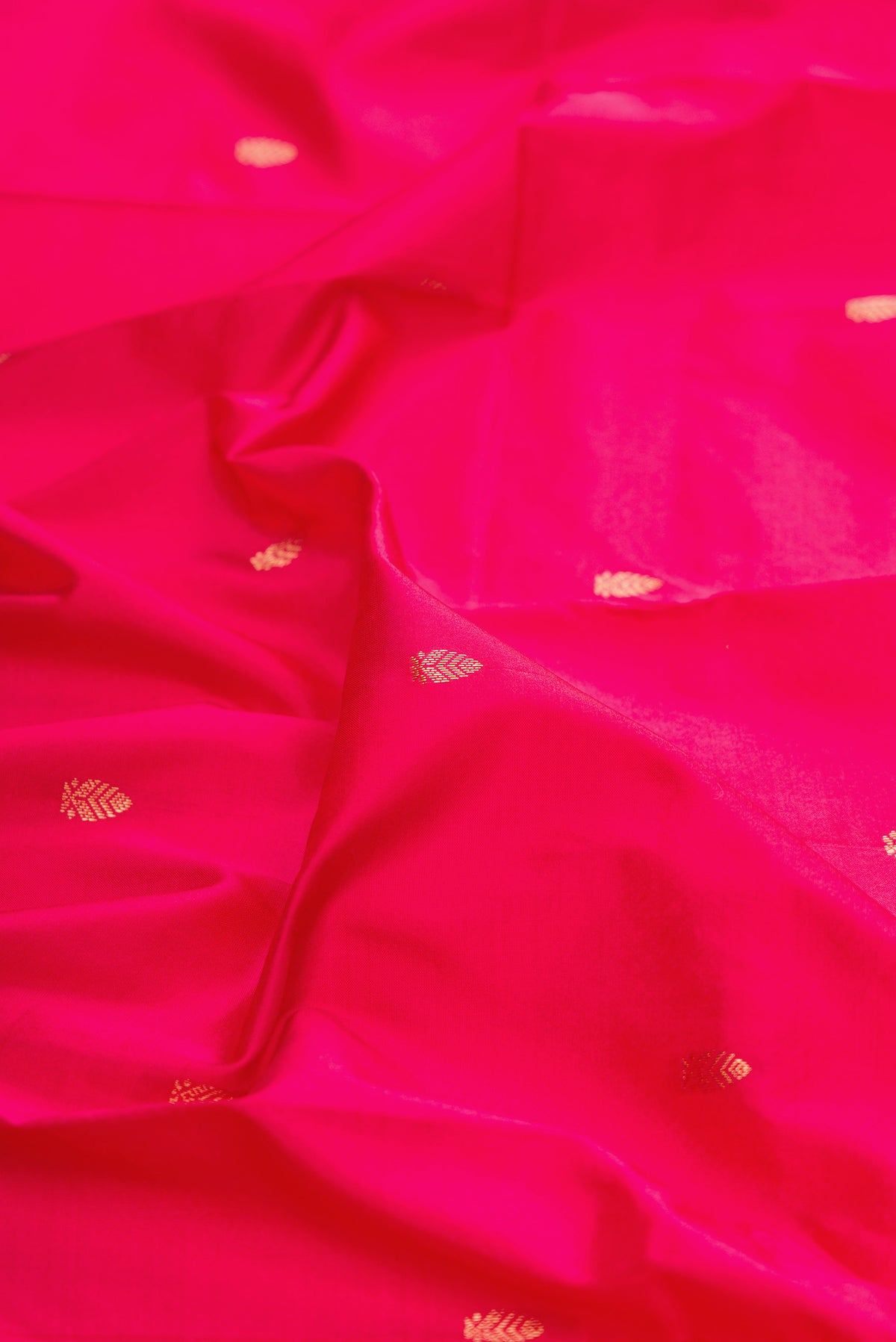Close up of Pure Silk Dark Pink Bangalore Saree with Zari Butta on the body and Zari Border.  displaying folds