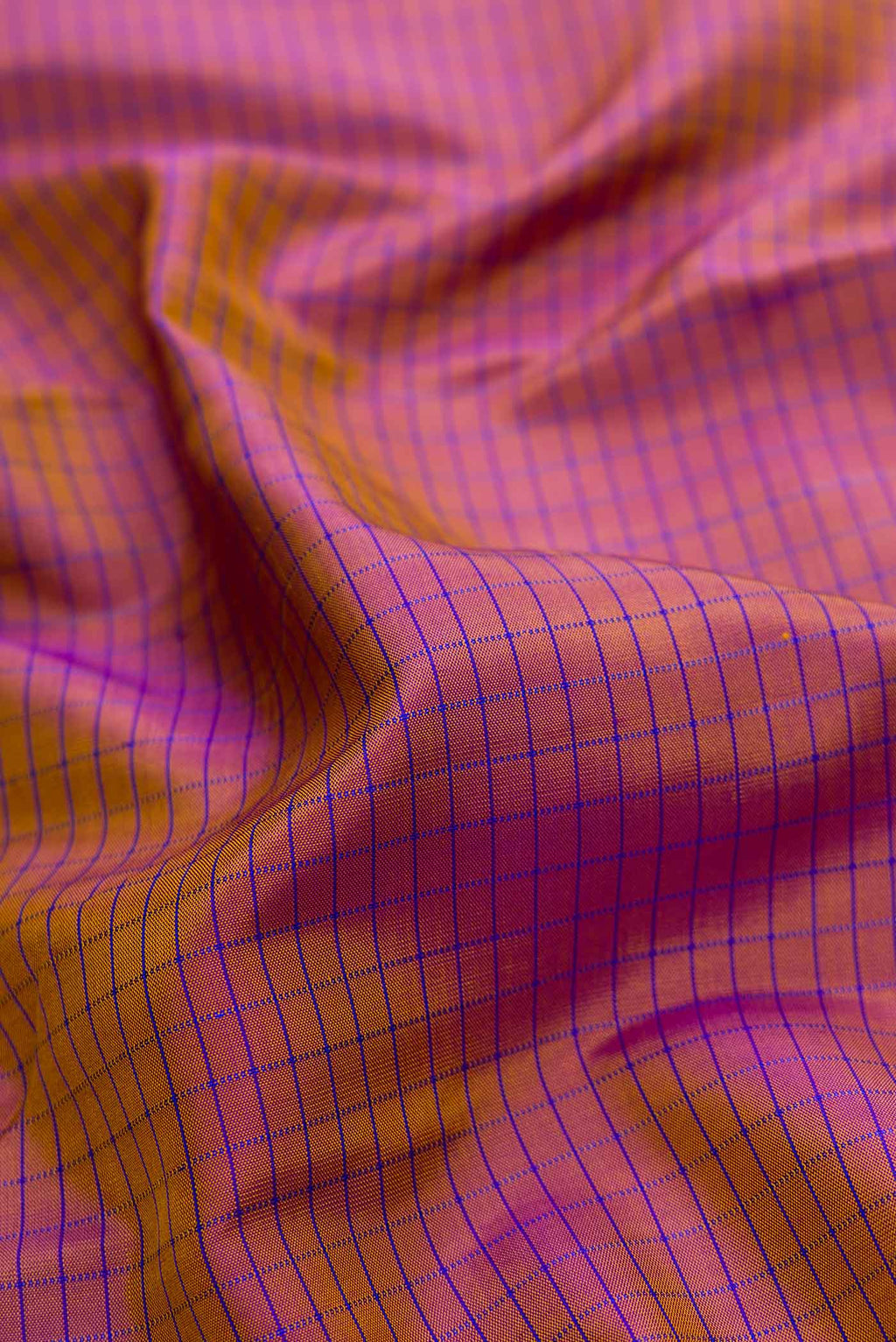 Close up of Brown Dual Tone Kanchipuram Silk Saree with Checked design on the body and Fancy Border.  displaying folds