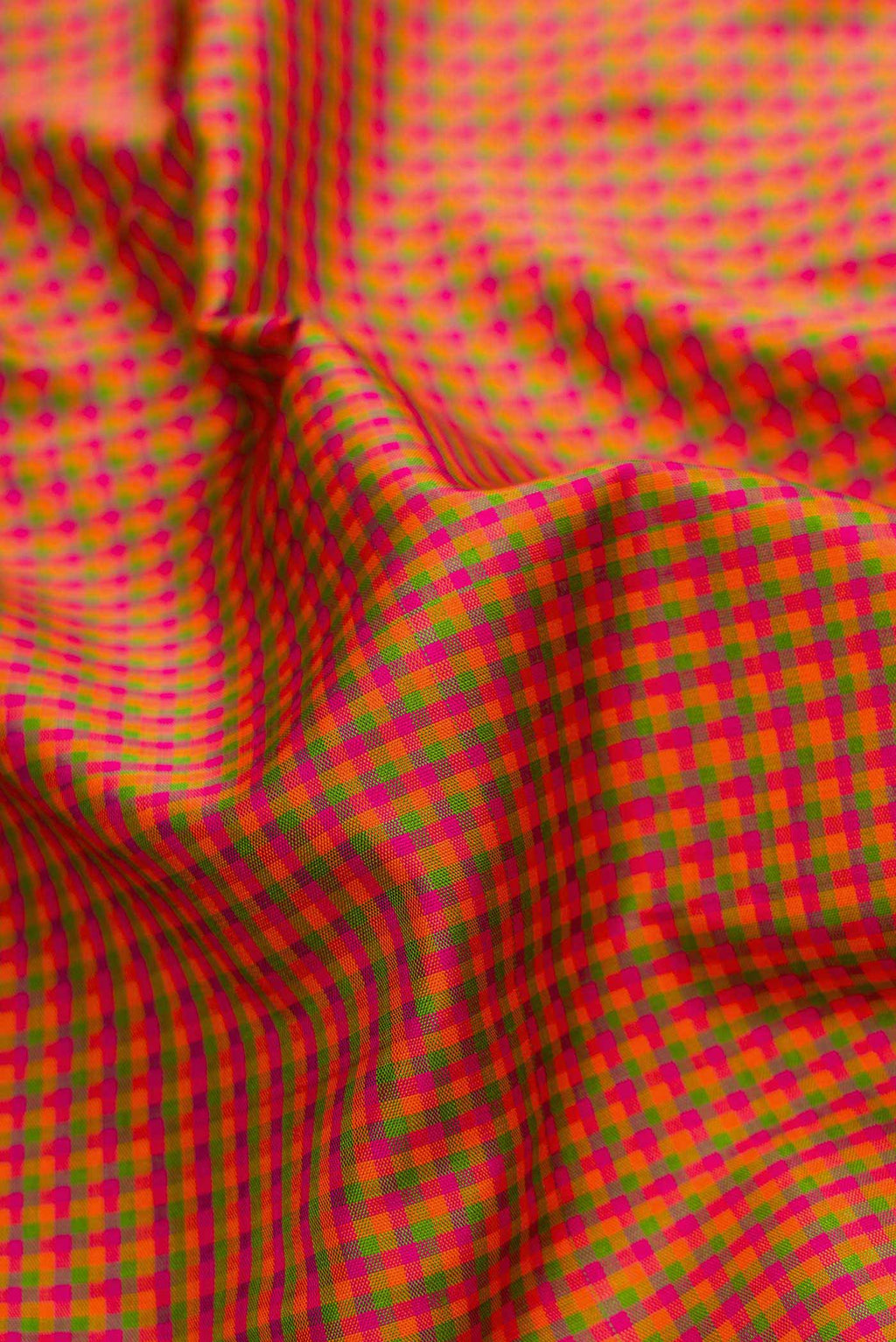 Close up of Pink, Green and Orange Color Kanjivaram Silk Saree with Checked design on the body and Zari Border.  displaying folds