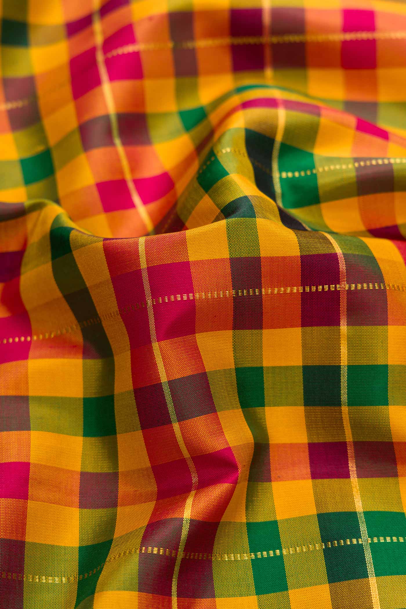 Close up of Mustard, Green and Maroon Color Kanchipuram Silk Saree with Checked design on the body and Zari Border displaying folds
