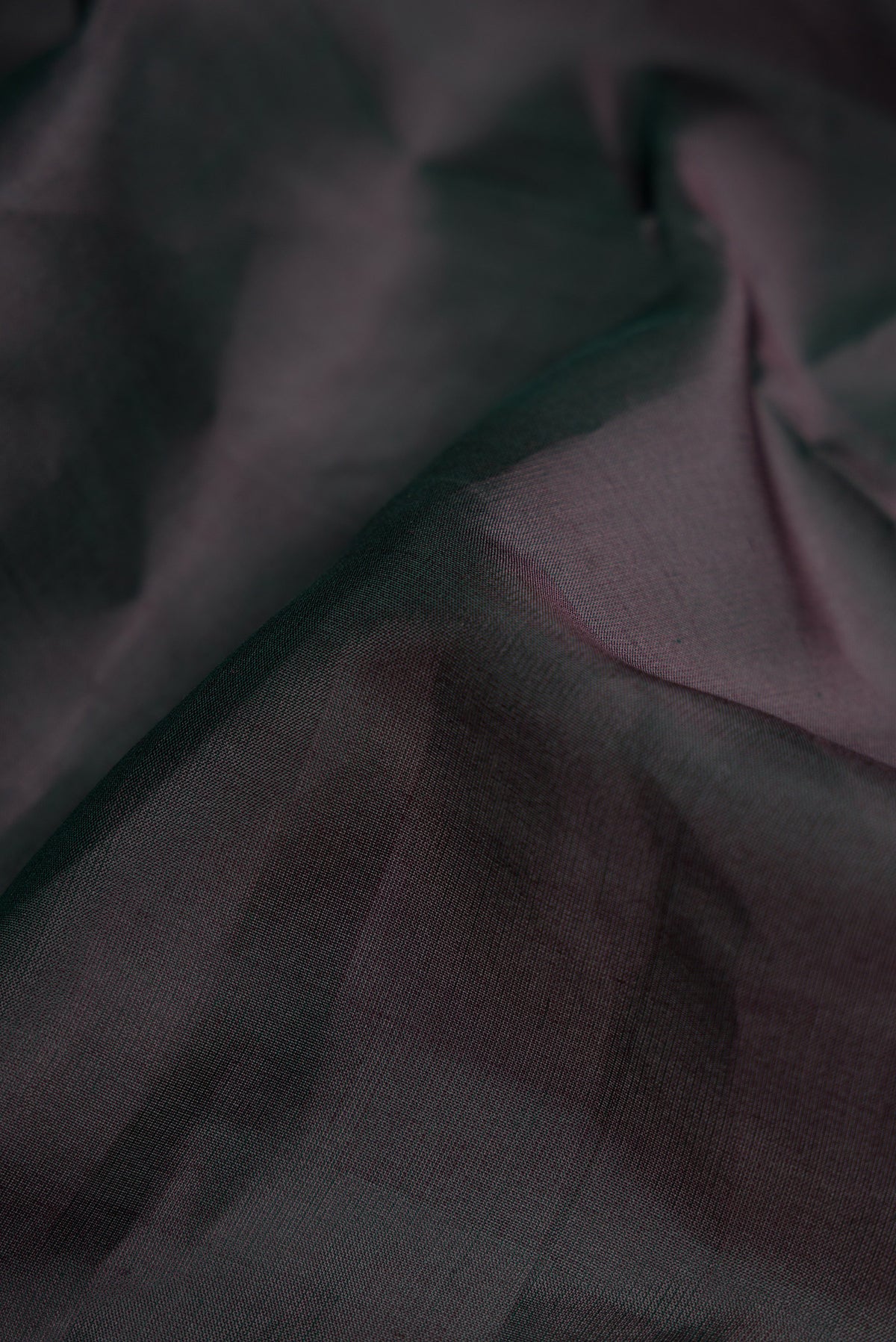 Close up of Black Dual Tone Kanjivaram Silk Nine Yards Saree with Plain Body and Zari Border.  displaying folds