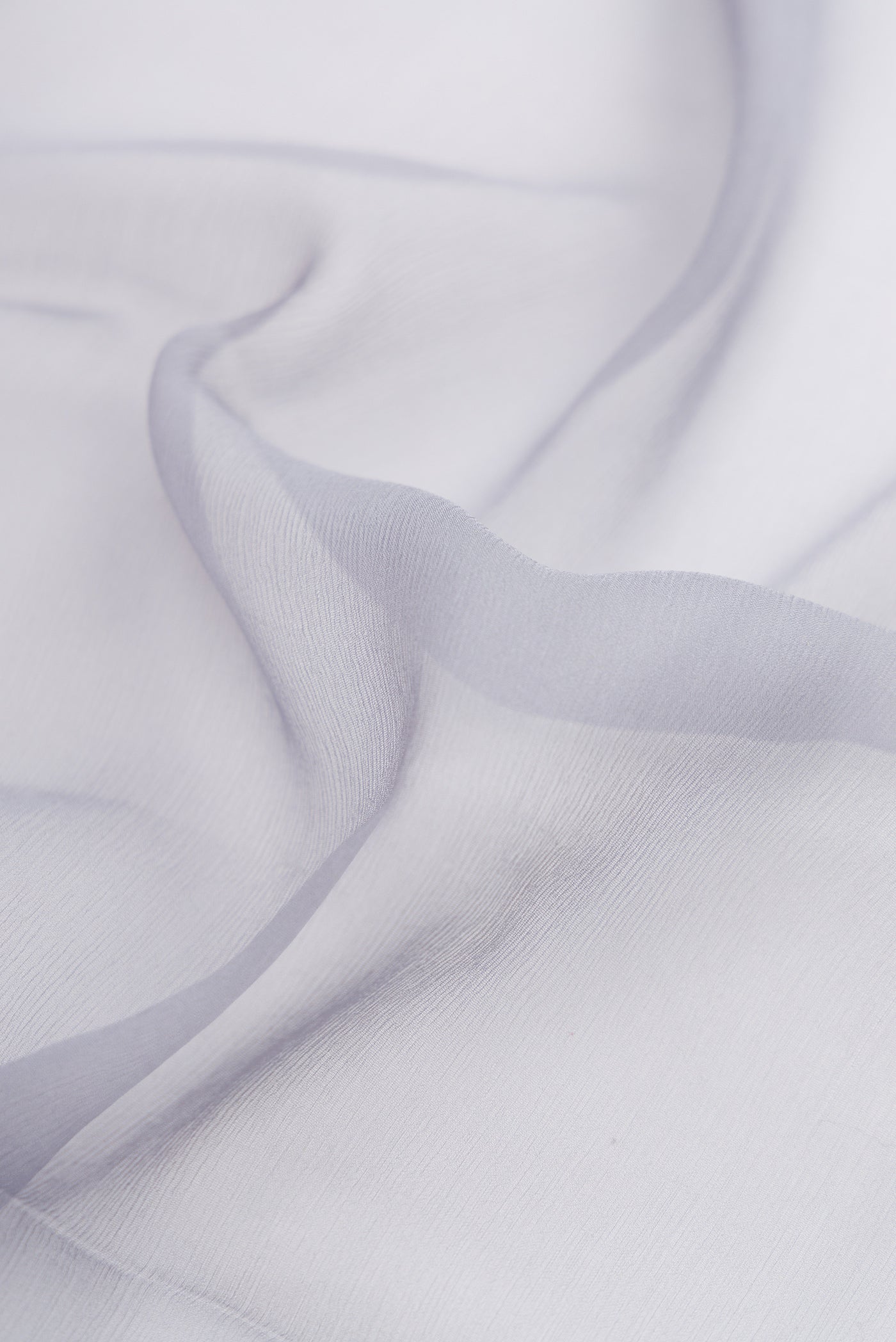 Close up of Grey Mysore Chiffon Saree with Plain Body and Zari Border.  displaying folds