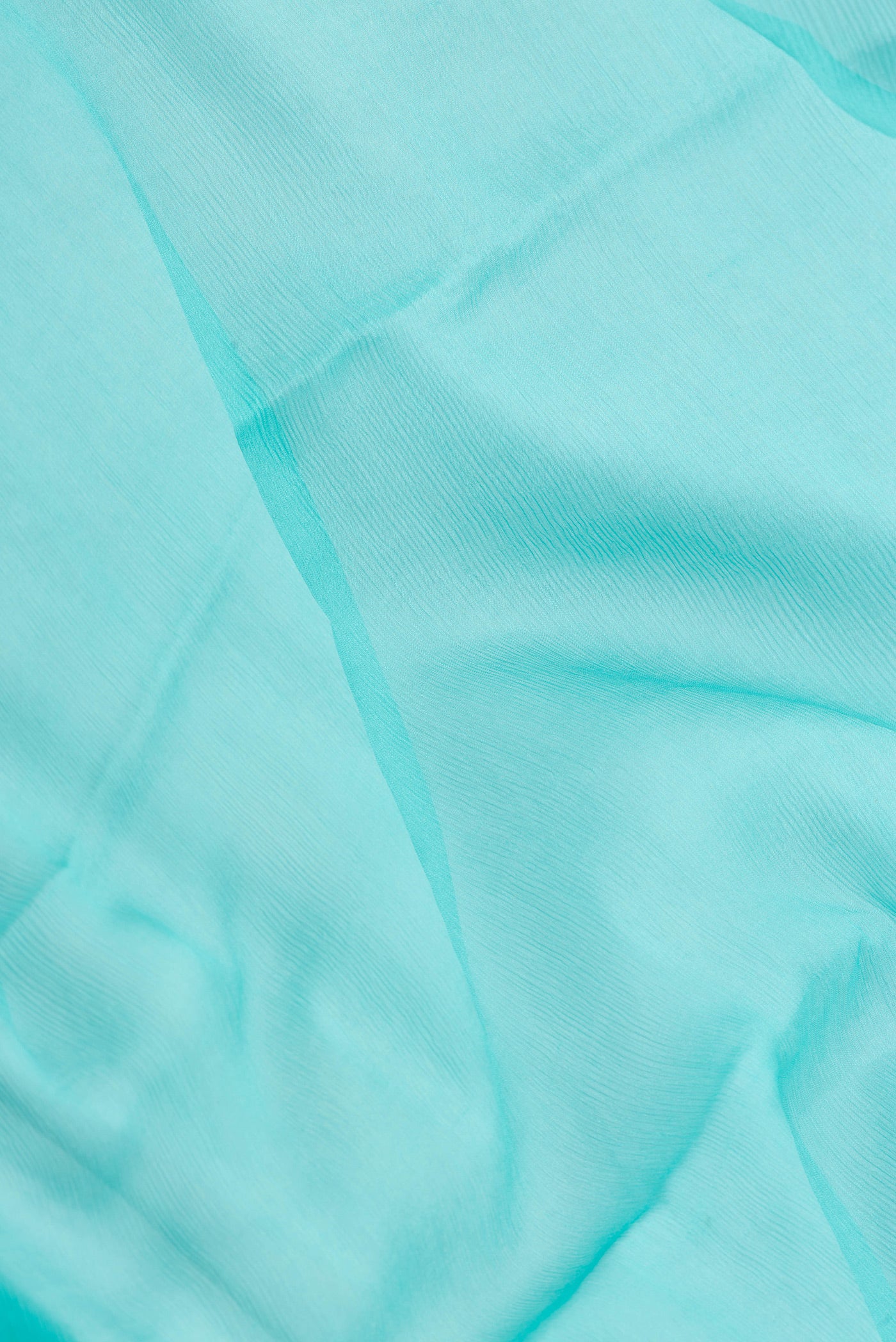 Close up of Sky Blue Mysore Chiffon Saree with Plain Body and Zari Border.  displaying folds