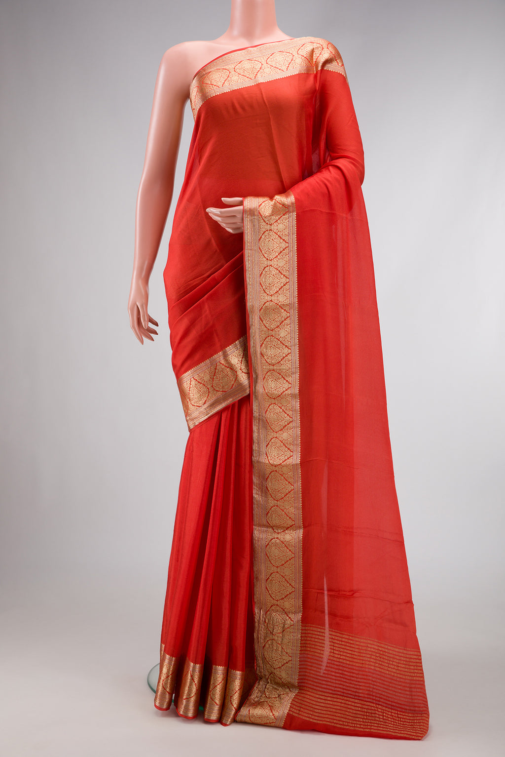 Brick Orange Dual Tone Mysore Georgette Saree with Plain Body and Zari Border.  displayed on a mannequin