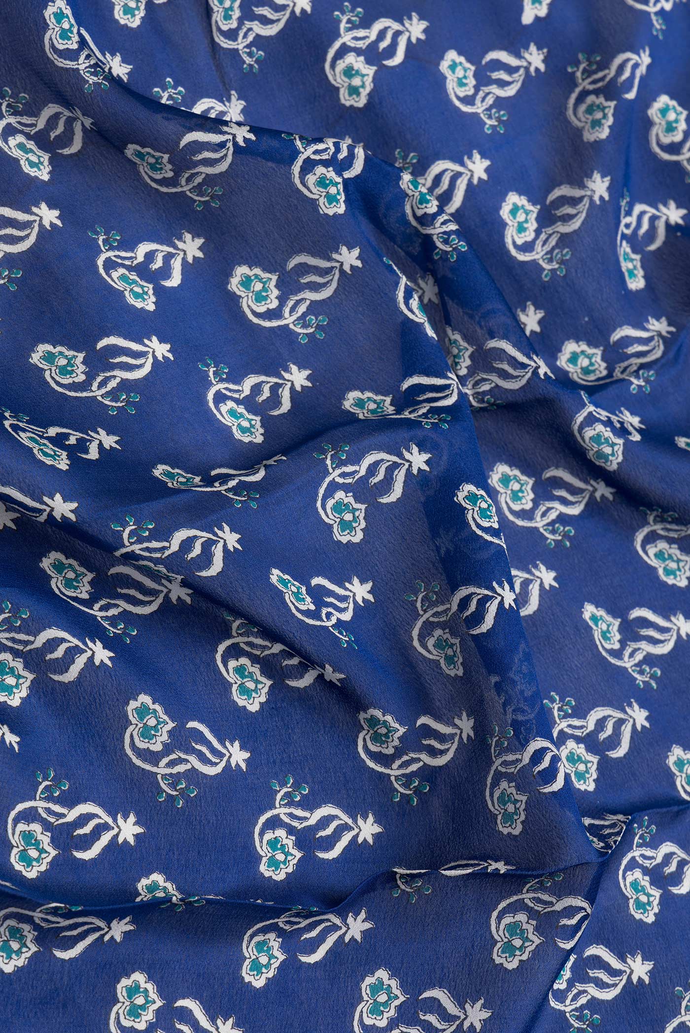 Close up of Navy Blue Dual Tone Mysore Crepe Saree with Printed design on the body and Zari Border.  displaying folds