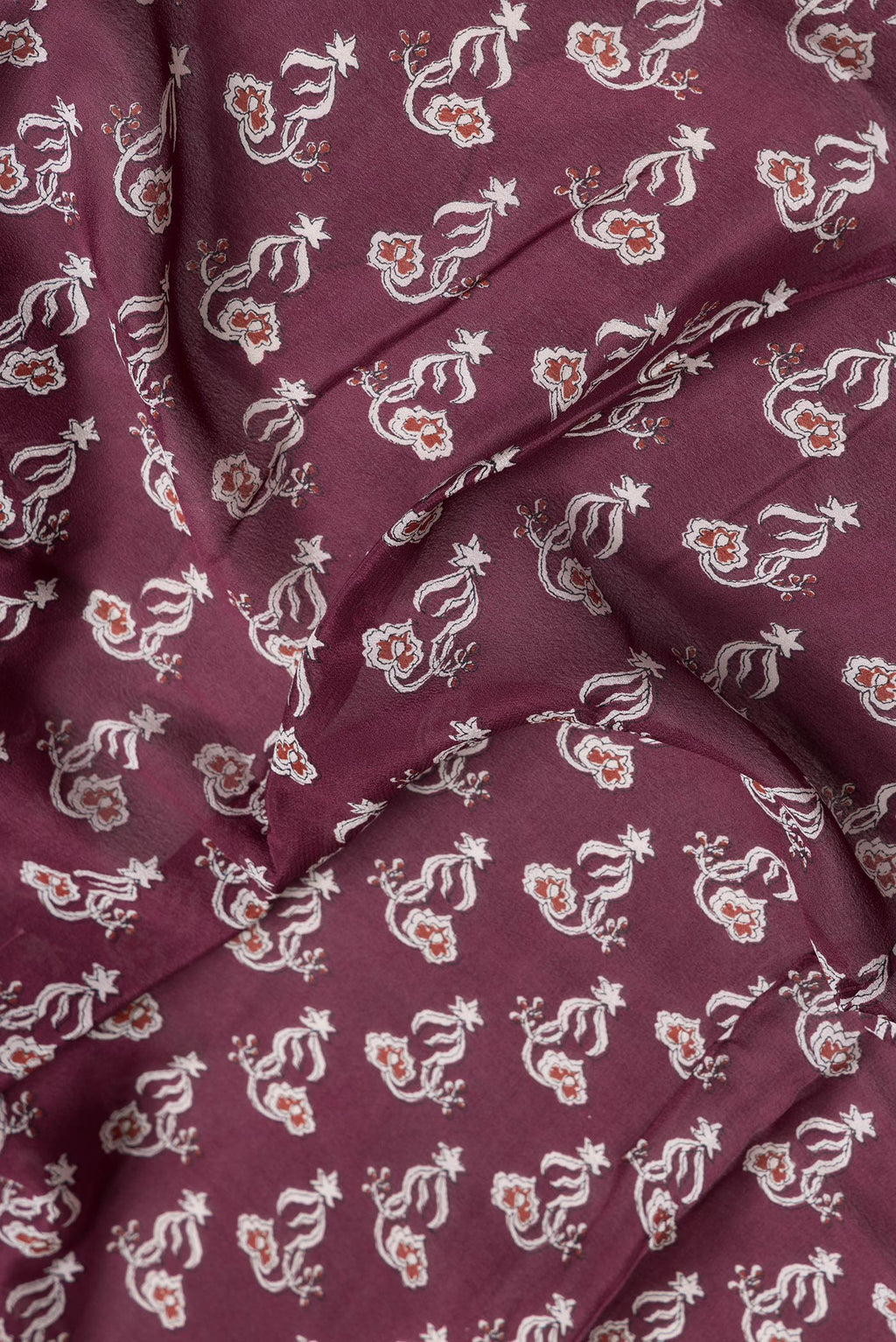 Close up of Maroon Dual Tone Mysore Crepe Saree with Printed design on the body and Zari Border.  displaying folds