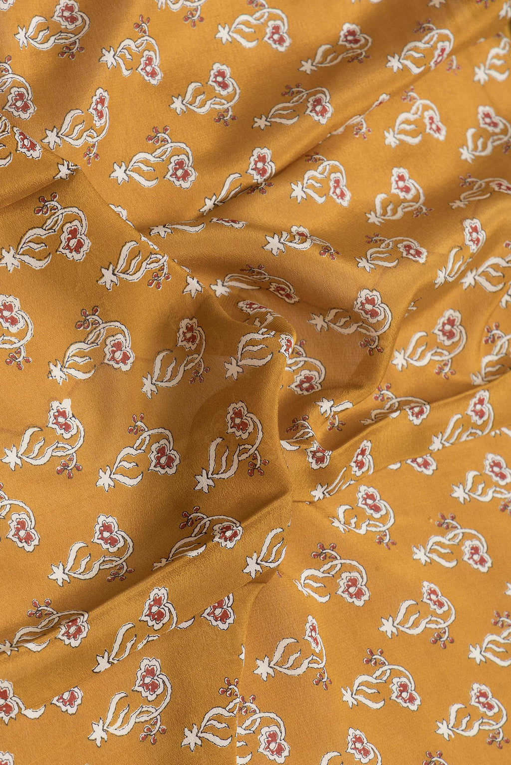 Close up of Mustard Dual Tone Mysore Crepe Saree with Printed design on the body and Zari Border.  displaying folds