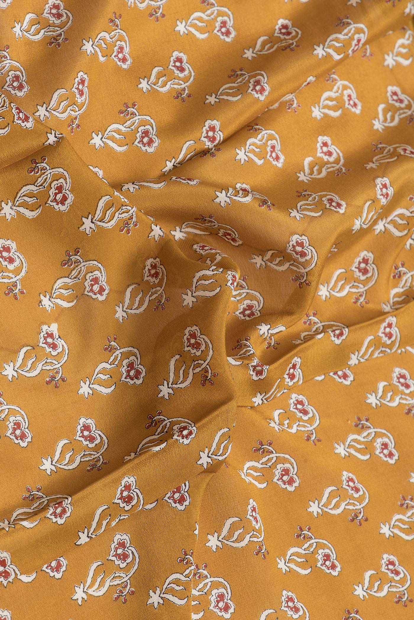 Close up of Mustard Dual Tone Mysore Crepe Saree with Printed design on the body and Zari Border.  displaying folds