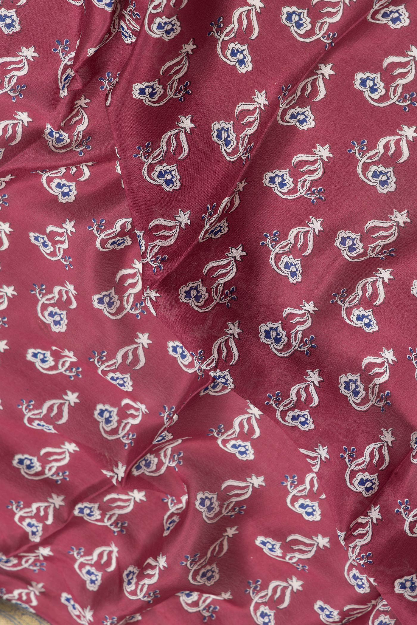 Close up of Maroon Dual Tone Mysore Crepe Saree with Printed design on the body and Zari Border.  displaying folds