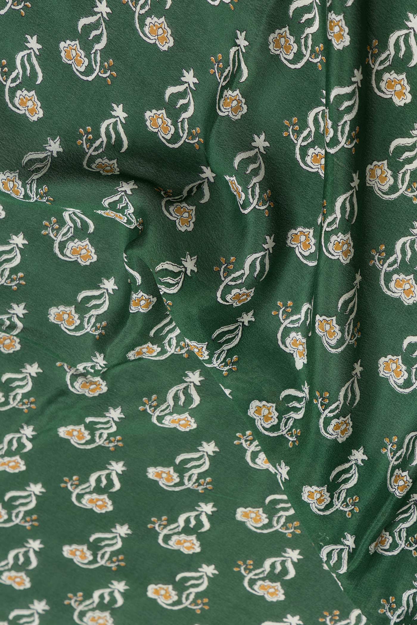 Close up of Green Dual Tone Mysore Crepe Saree with Printed design on the body and Zari Border.  displaying folds