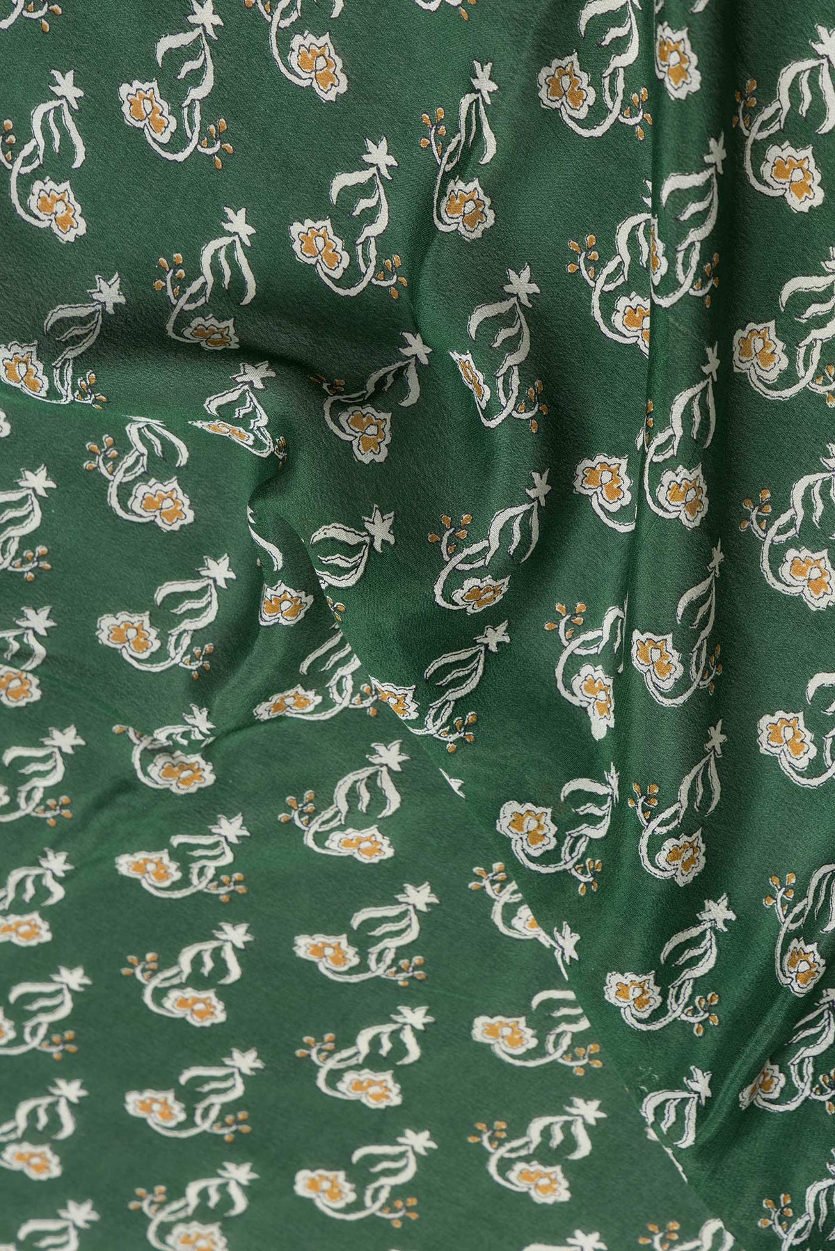 Close up of Green Dual Tone Mysore Crepe Saree with Printed design on the body and Zari Border.  displaying folds