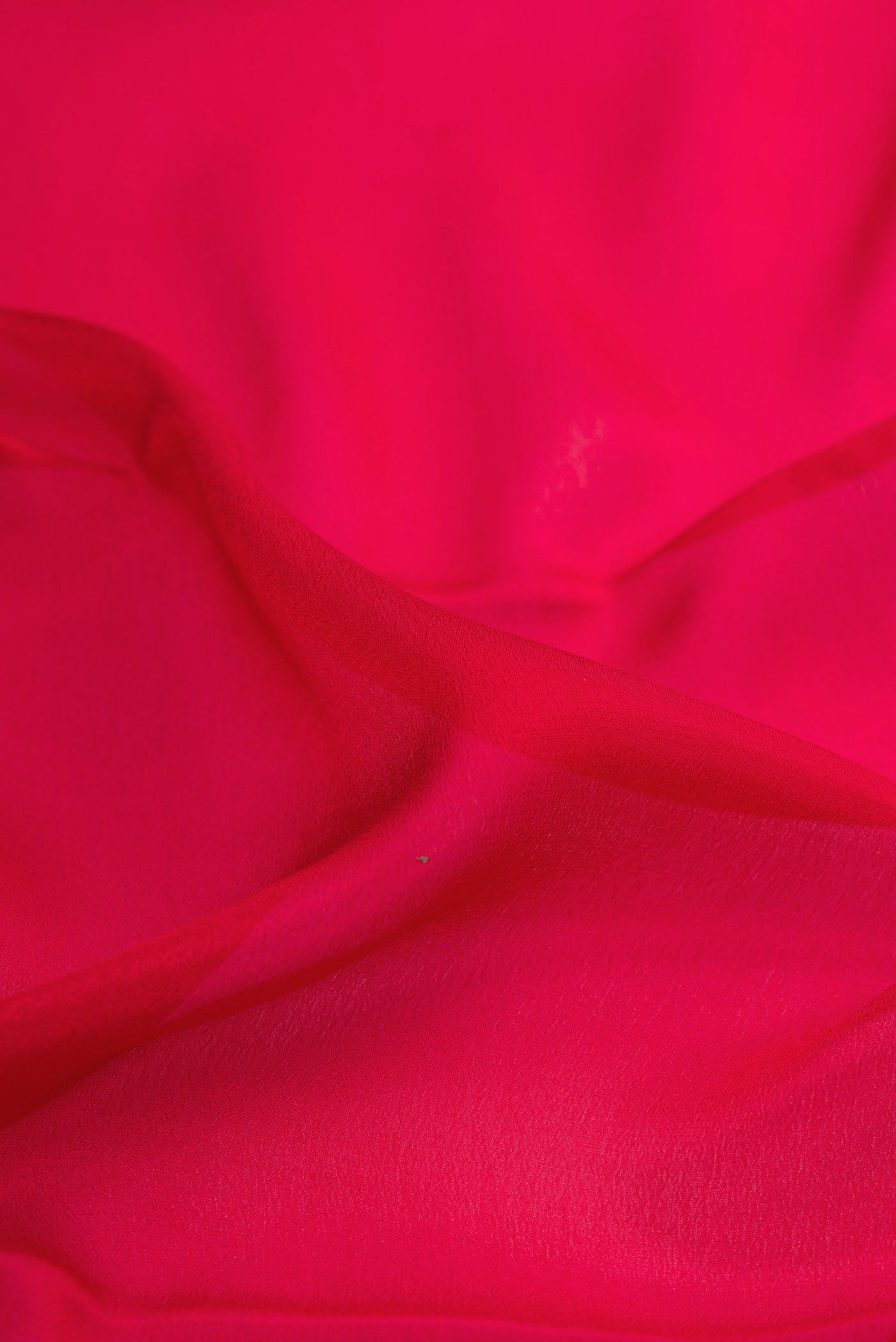 Close up of Red Dual Tone Mysore Crepe Saree with Plain Body and Zari Border.  displaying folds