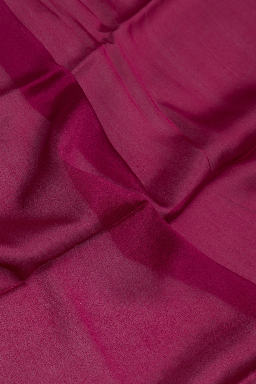 Close up of Magenta Dual Tone Georgette Saree with Plain Body and Zari Border.  displaying folds