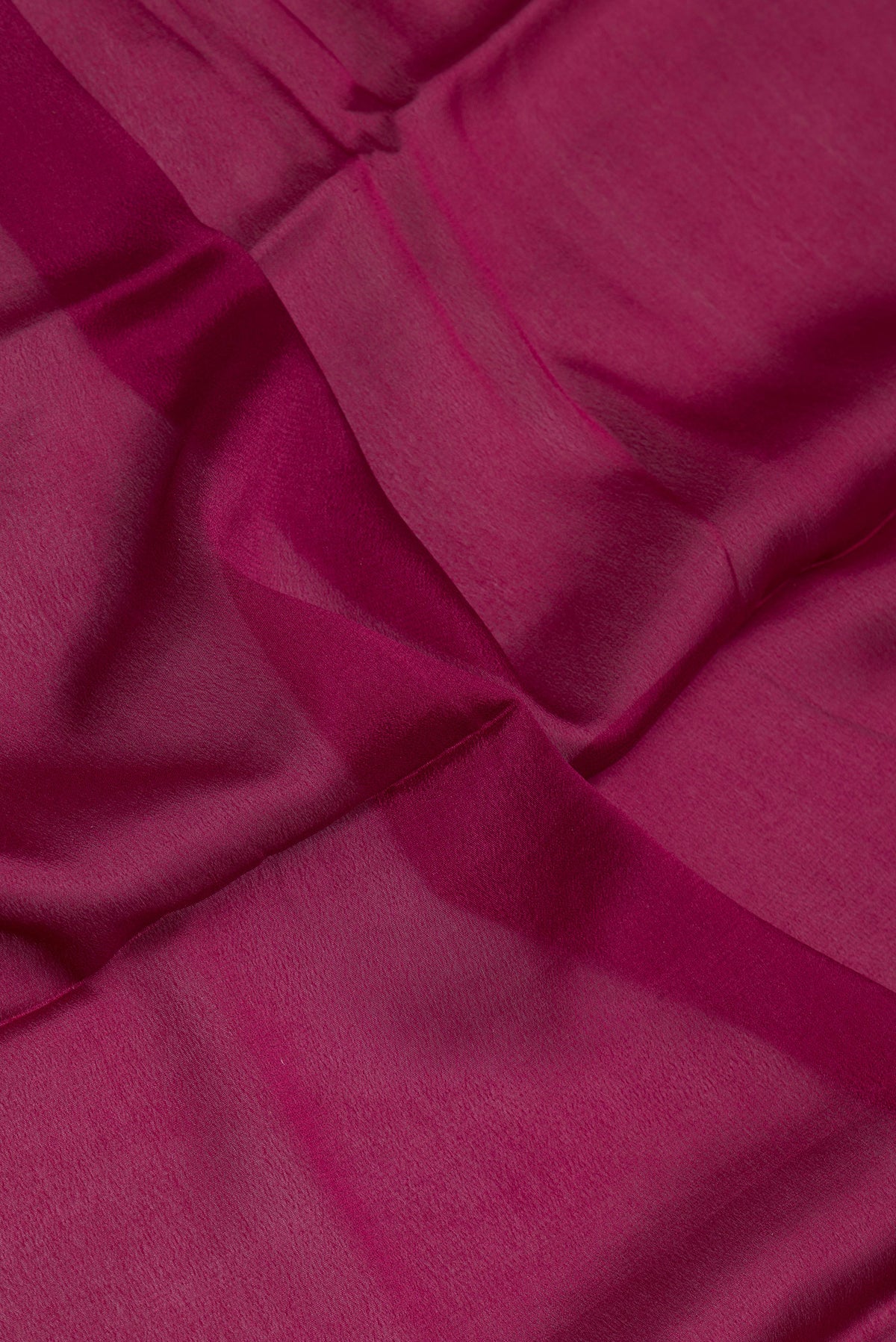 Close up of Magenta Dual Tone Georgette Saree with Plain Body and Zari Border.  displaying folds