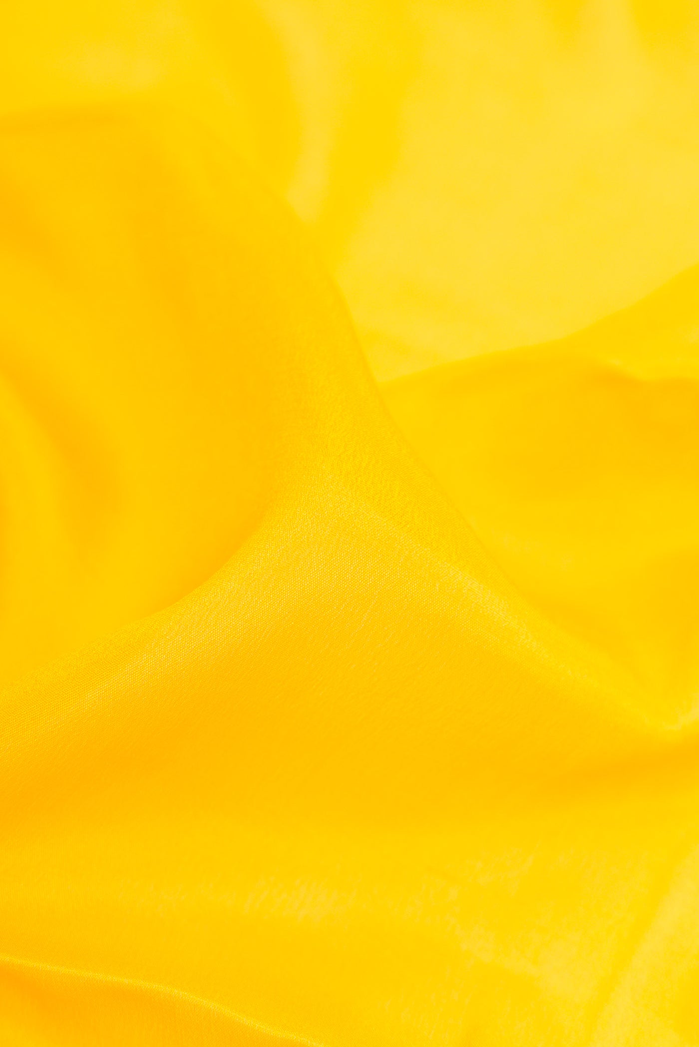 Close up of Yellow Mysore Crepe Saree with Plain Body and Zari Border.  displaying folds