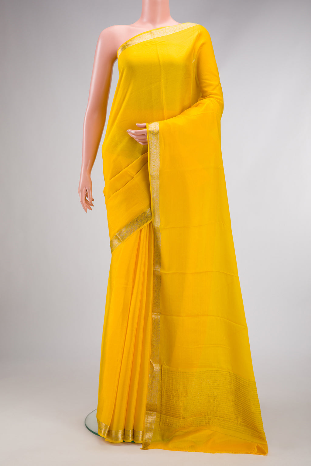 Yellow Mysore Crepe Saree with Plain Body and Zari Border.  displayed on a mannequin