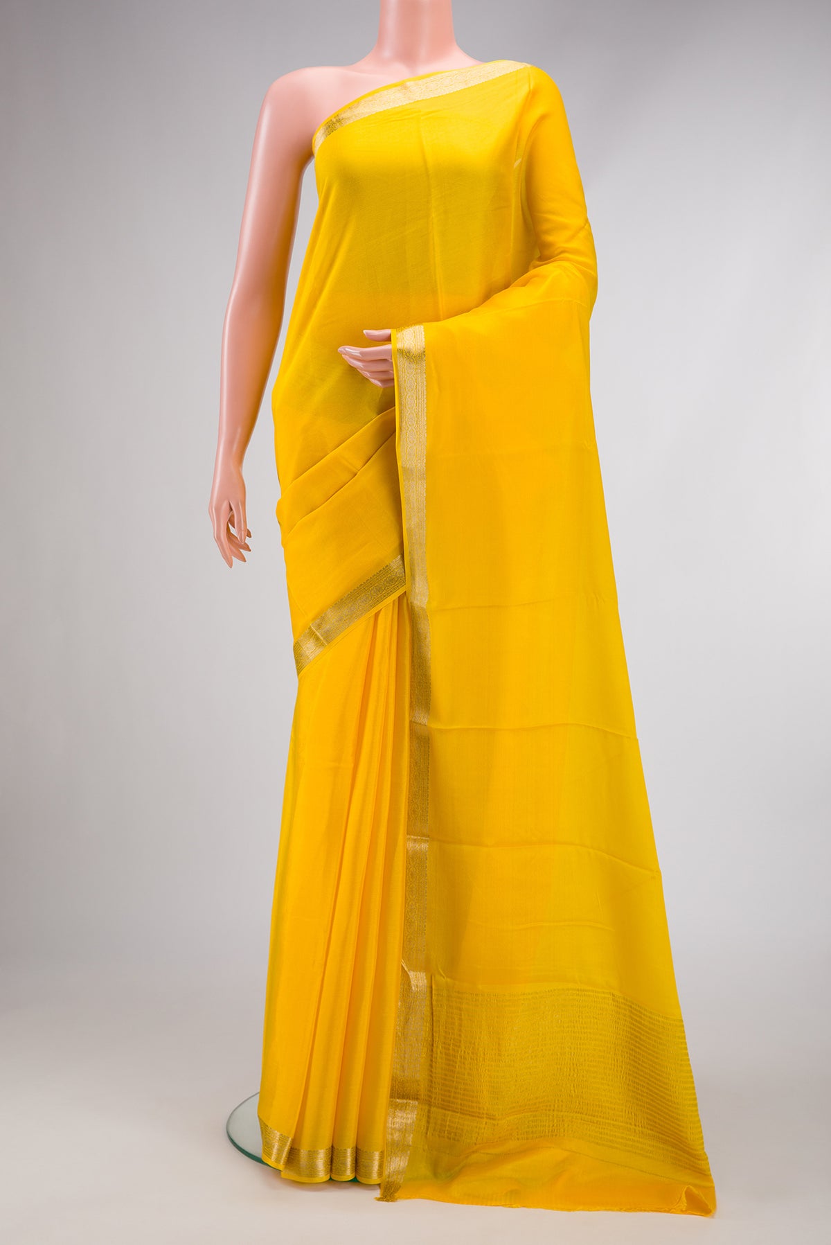 Yellow Mysore Crepe Saree with Plain Body and Zari Border.  displayed on a mannequin