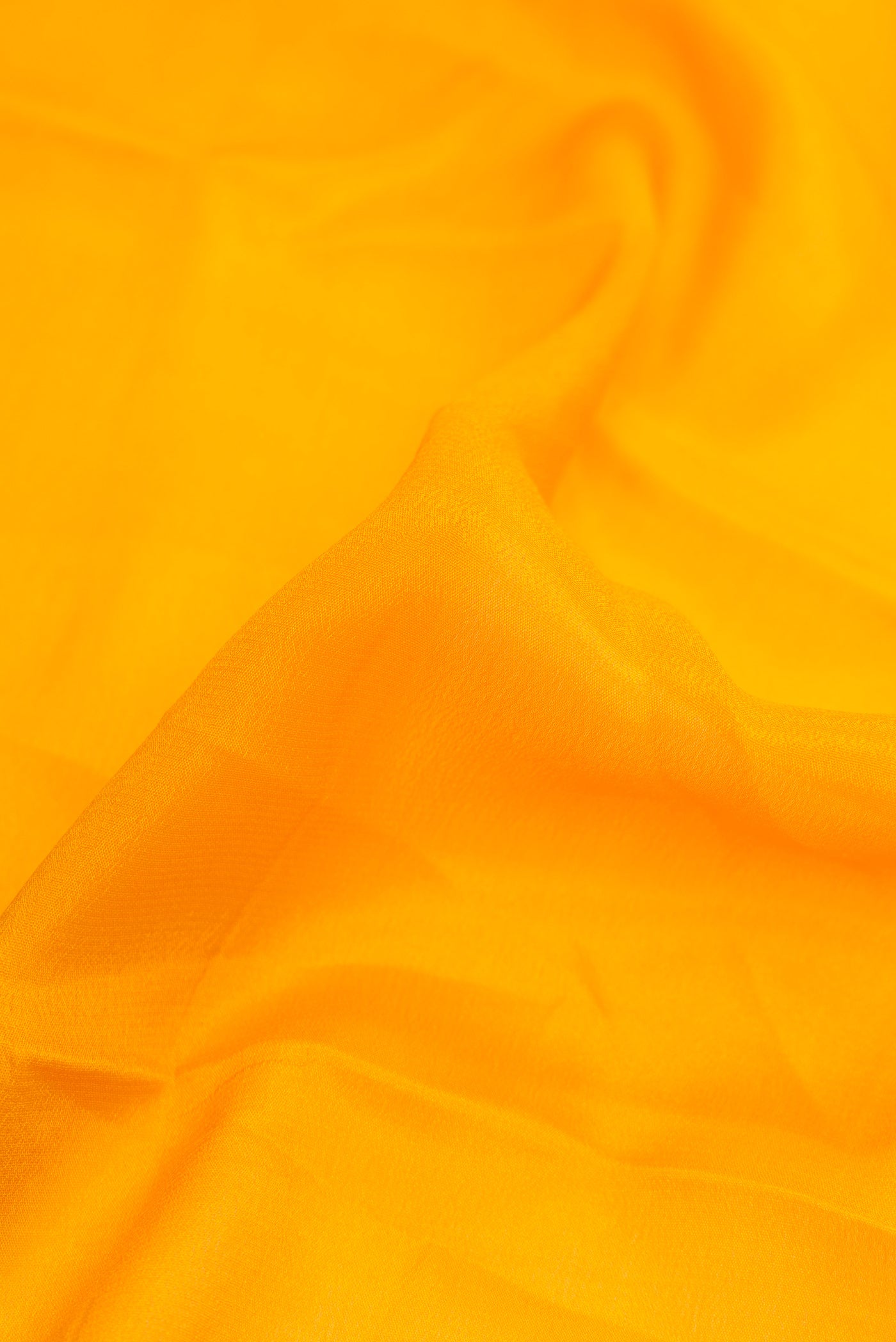 Close up of Yellow Dual Tone Mysore Georgette Saree with Plain Body and Zari Border.  displaying folds