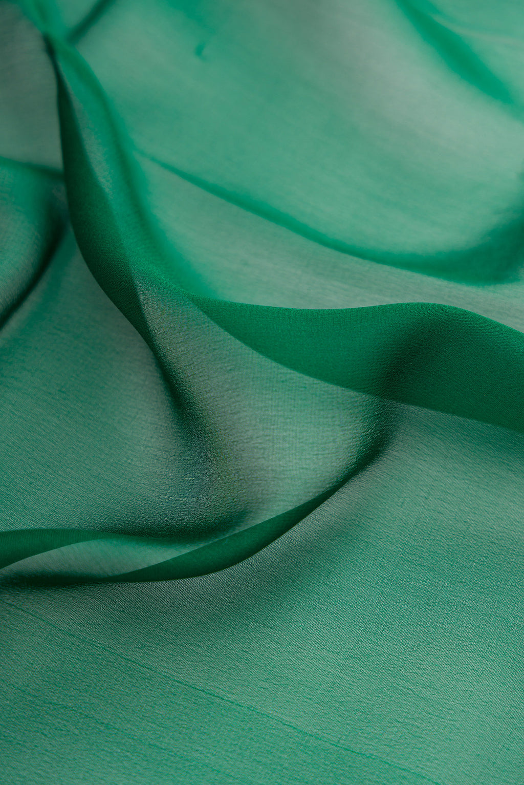 Close up of Bottle Green Mysore Georgette Saree with Plain Body and Zari Border.  displaying folds