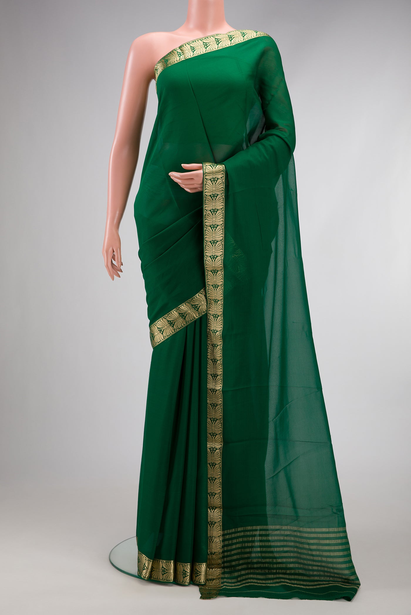 Bottle Green Mysore Georgette Saree with Plain Body and Zari Border.  displayed on a mannequin
